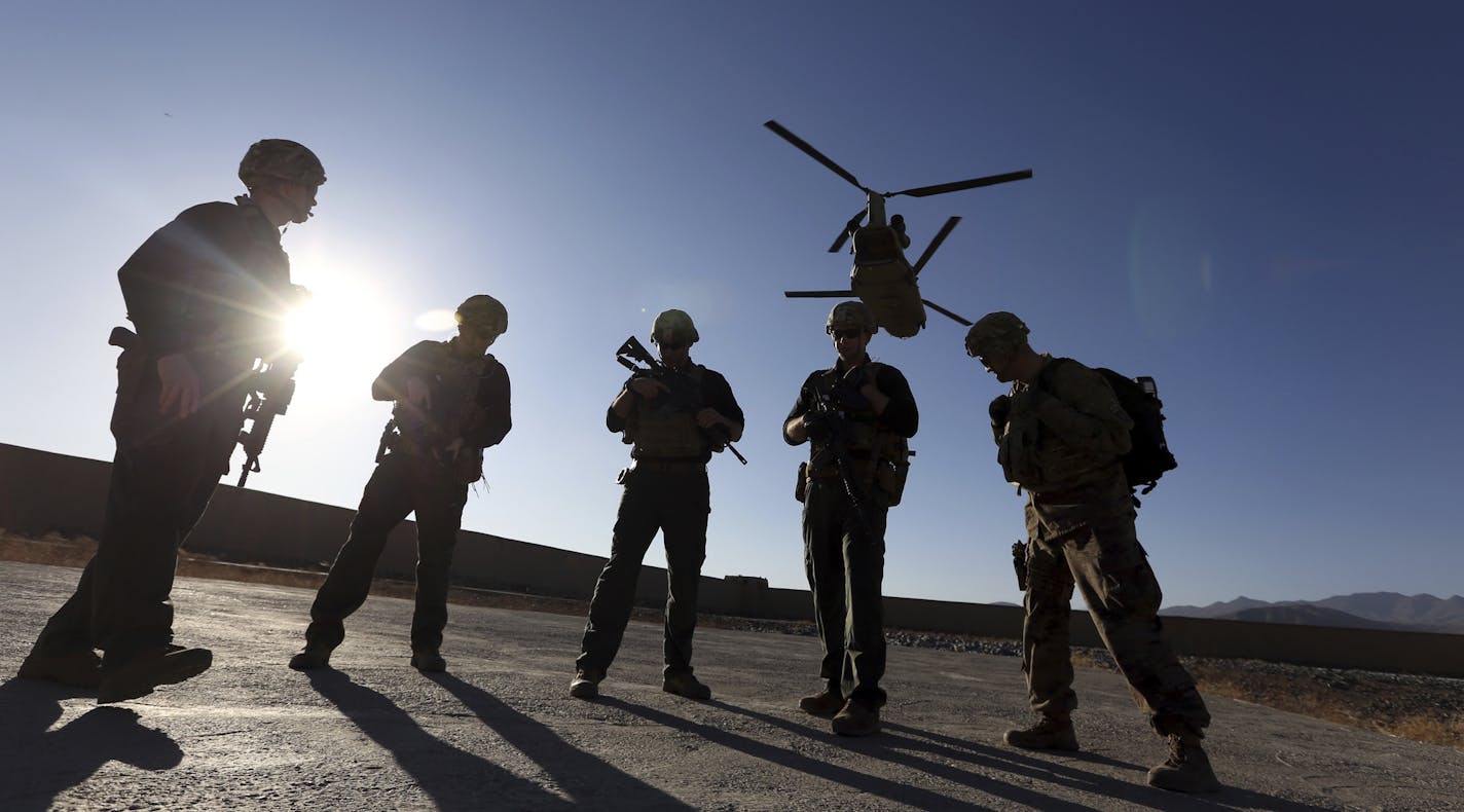 FILE - In this Nov. 30, 2017 file photo, American soldiers wait on the tarmac in Logar province, Afghanistan. Top officials in the White House were aware in early 2019 of classified intelligence indicating Russia was secretly offering bounties to the Taliban for the deaths of Americans, a full year earlier than has been previously reported. (AP Photo/Rahmat Gul, File)