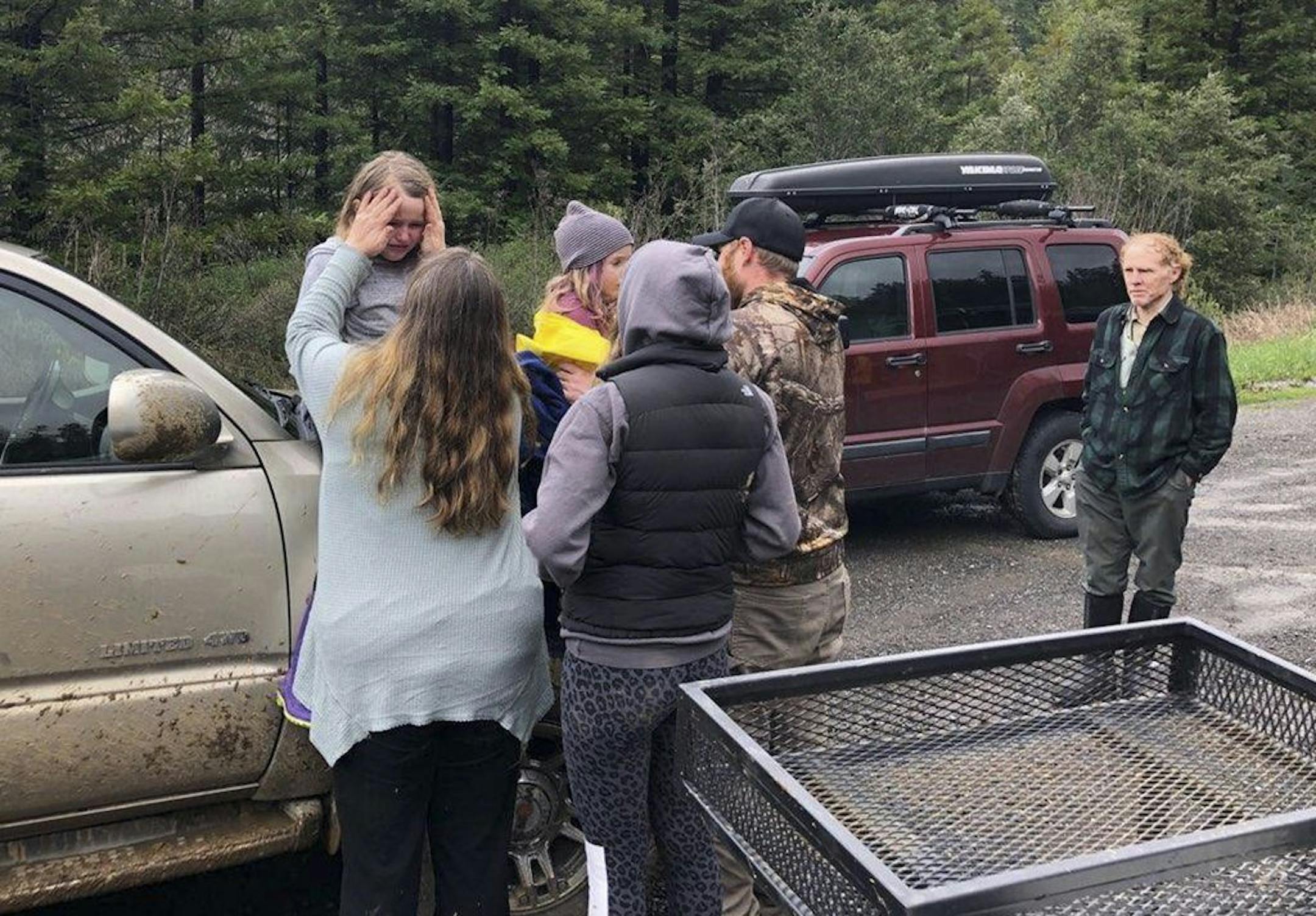This Sunday, March 3, 2019 photo provided by the Humboldt County Sheriff's Office shows 5- and 8-year-old sisters Leia, left and Caroline Carrico being comforted after they were found and reunited with their family in Denbow, Calif. on Sunday, March 3, 2019, after they survived 44 hours in rugged Northern California wilderness. Armed with some outdoor survival training, granola bars and pink rubber boots, the sisters were found dehydrated and cold but in good spirits on Sunday, authorities said.
