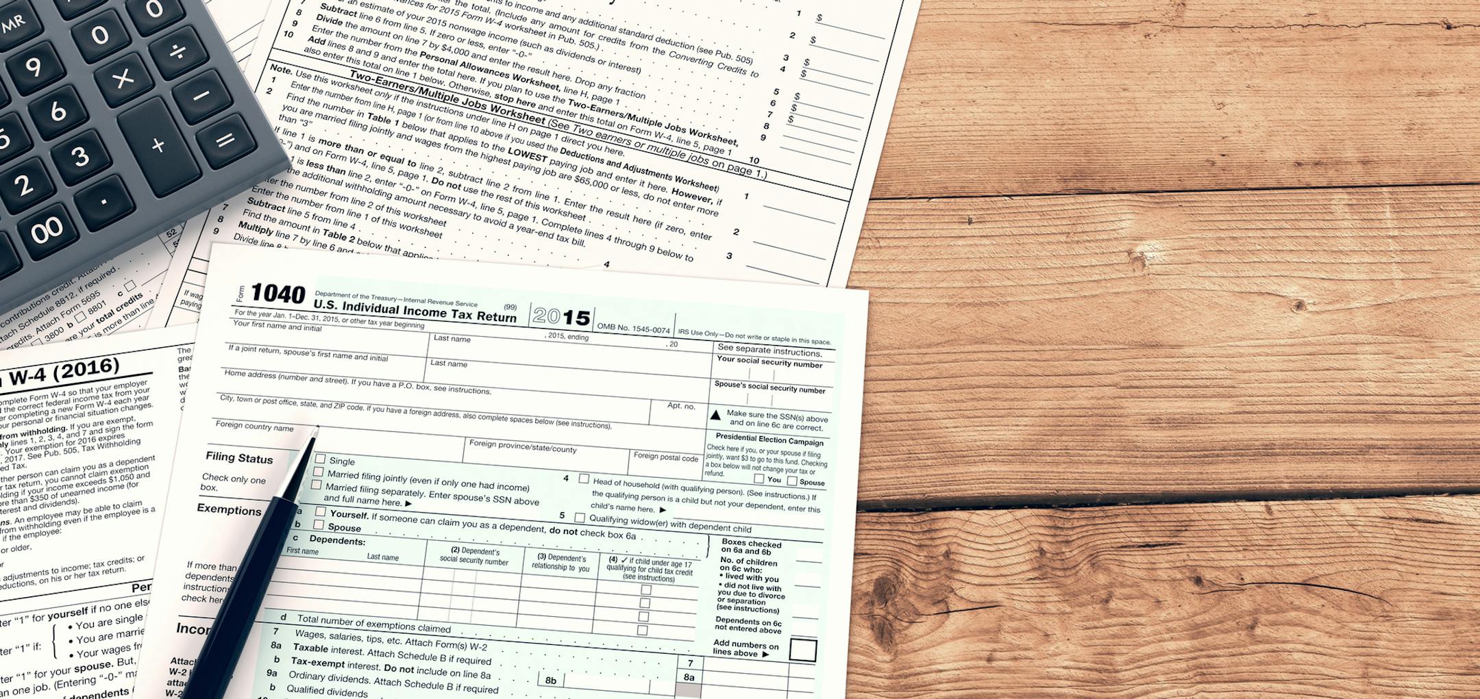 top view of forms for usa taxes with a pen and an electronic calculator, empty spaces for custom text at the right (3d render). istock