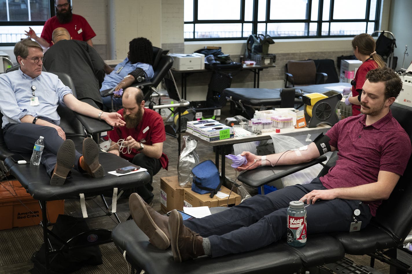 Ben Pelton, right, and Dr. Timothy Sielaff, who was assisted by Travis Wolfe of the Red Cross, donated blood at Allina Commons on March 19. State health officials are asking for people to safely donate, and organizations are creating new drives that meet social distancing conditions.