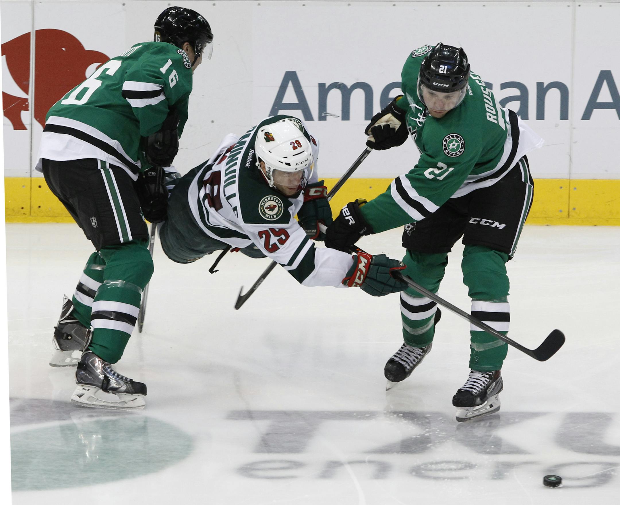 Dallas Stars left wing Ryan Garbutt (16) and Antoine Roussel (21) vie with Minnesota Wild right wing Jason Pominville (29) for the puck in the third period during an NHL hockey game in Dallas on Saturday, March 8, 2014. The Stars won 4-3. (AP Photo/ Richard W. Rodriguez)