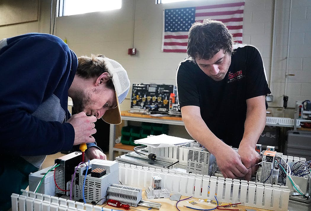 Pine Technical and Community College automated systems technology students Chris Carty, right, and Wes Berens assembled control panels.