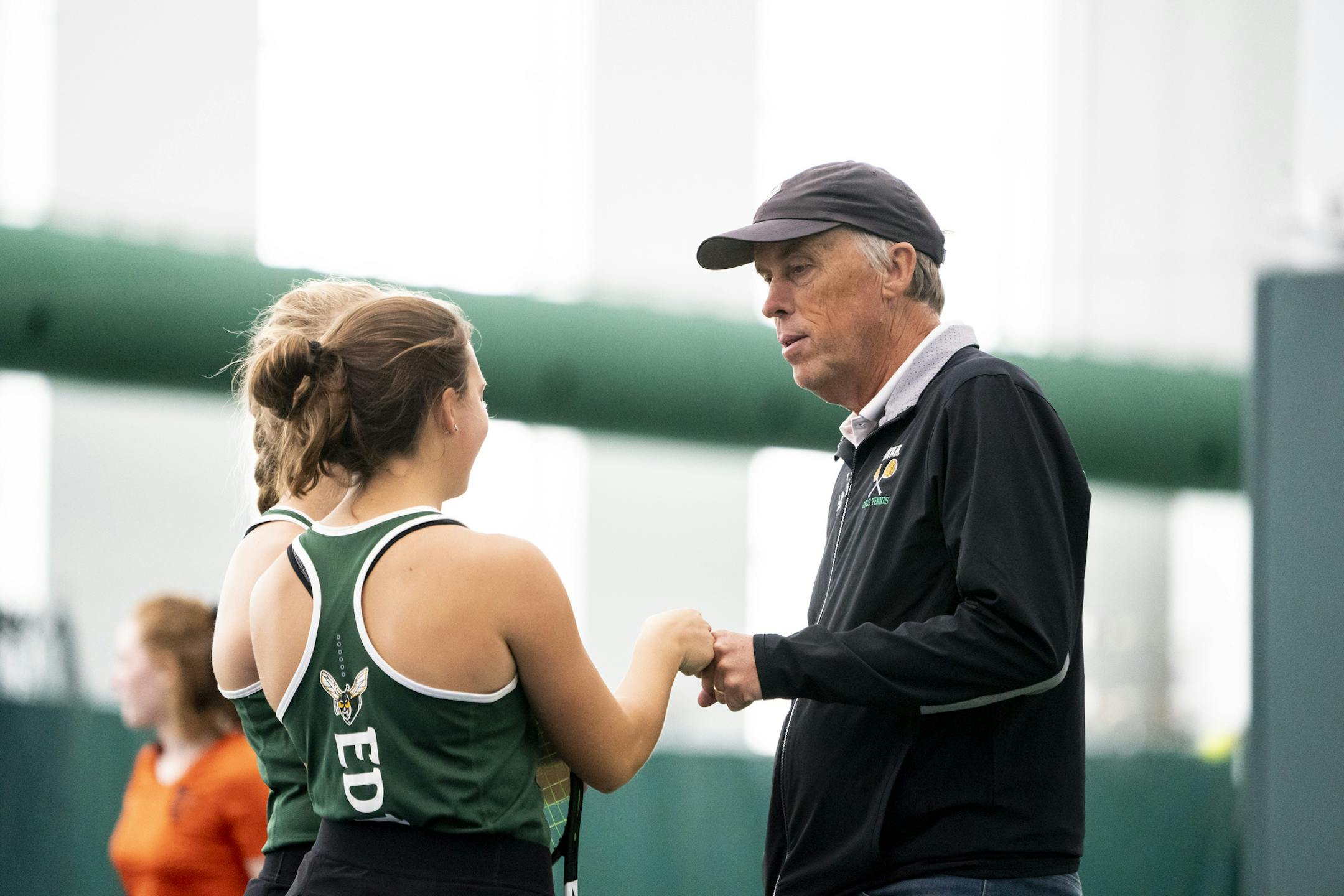 Coach Steve Paulsen gave Lizzy Van Ert a fist pump as she and Ingrid Smith played doubles on Oct. 14 during a section tournament match at Lifetime Fitness in Lakeville.