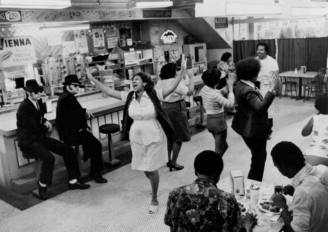 John Belushi, right, and Dan Aykroyd in 'The Blues Brothers' watch Aretha Franklin, as the owner of the Soul Food Cafe, sing 'Think!'