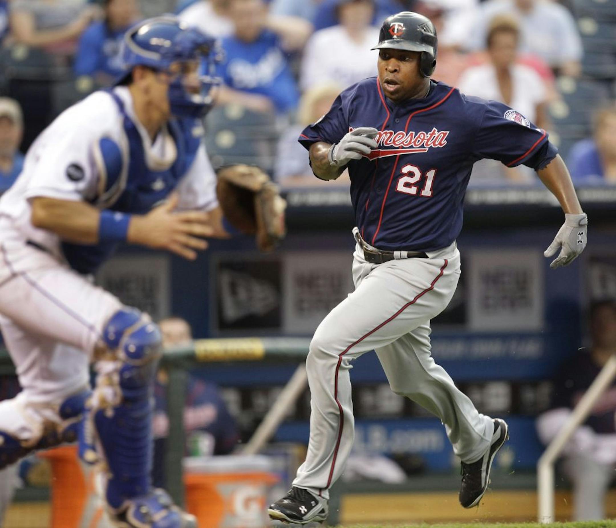 Minnesota Twins' Delmon Young (21) runs past Kansas City Royals catcher Matt Treanor to score on a single hit by Matt Tolbert during the third inning of a baseball game, Thursday, June 2, 2011, in Kansas City, Mo.