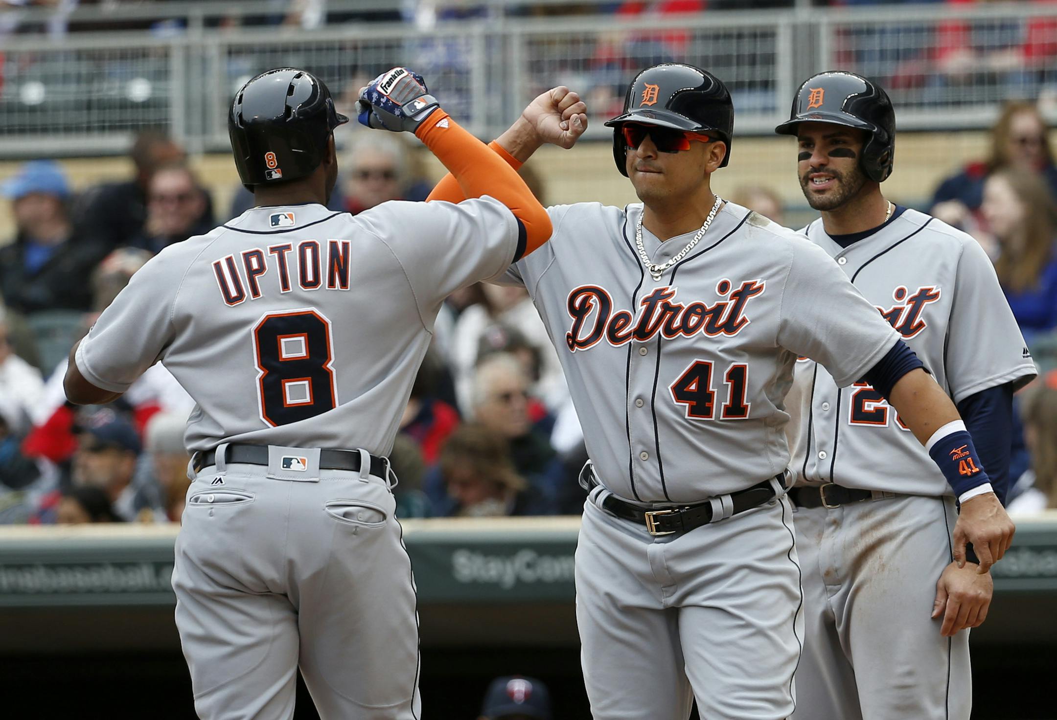 Detroit Tigers' Victor Martinez (41) and J.D. Martinez, right, welcome home Justin Upton (8) after Upton's three-run home run off Minnesota Twins starting pitcher Tyler Duffey during the first inning of a baseball game in Minneapolis, Saturday, April 30, 2016. (AP Photo/Ann Heisenfelt)