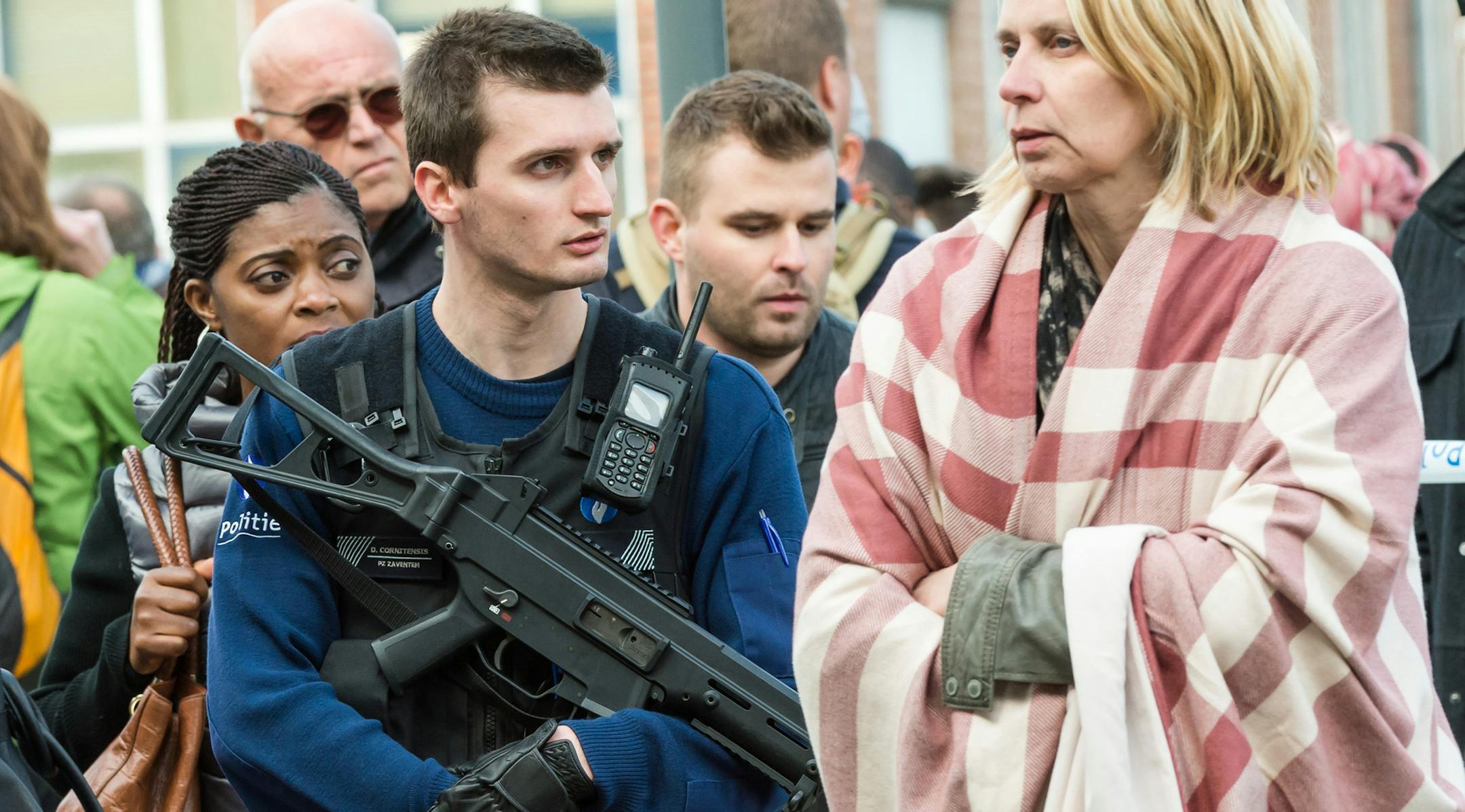 A police officer stands guard as people are evacuated from Brussels airport, after explosions rocked the facility in Brussels, Belgium, Tuesday March 22, 2016. Authorities locked down the Belgian capital on Tuesday after explosions rocked the Brussels airport and subway system, killing a number of people and injuring many more. Belgium raised its terror alert to its highest level, diverting arriving planes and trains and ordering people to stay where they were. Airports across Europe tightened s