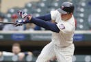 Minnesota Twins' Max Kepler follows through with an RBI single off Colorado Rockies pitcher Tyler Chatwood during the first inning of the second game 