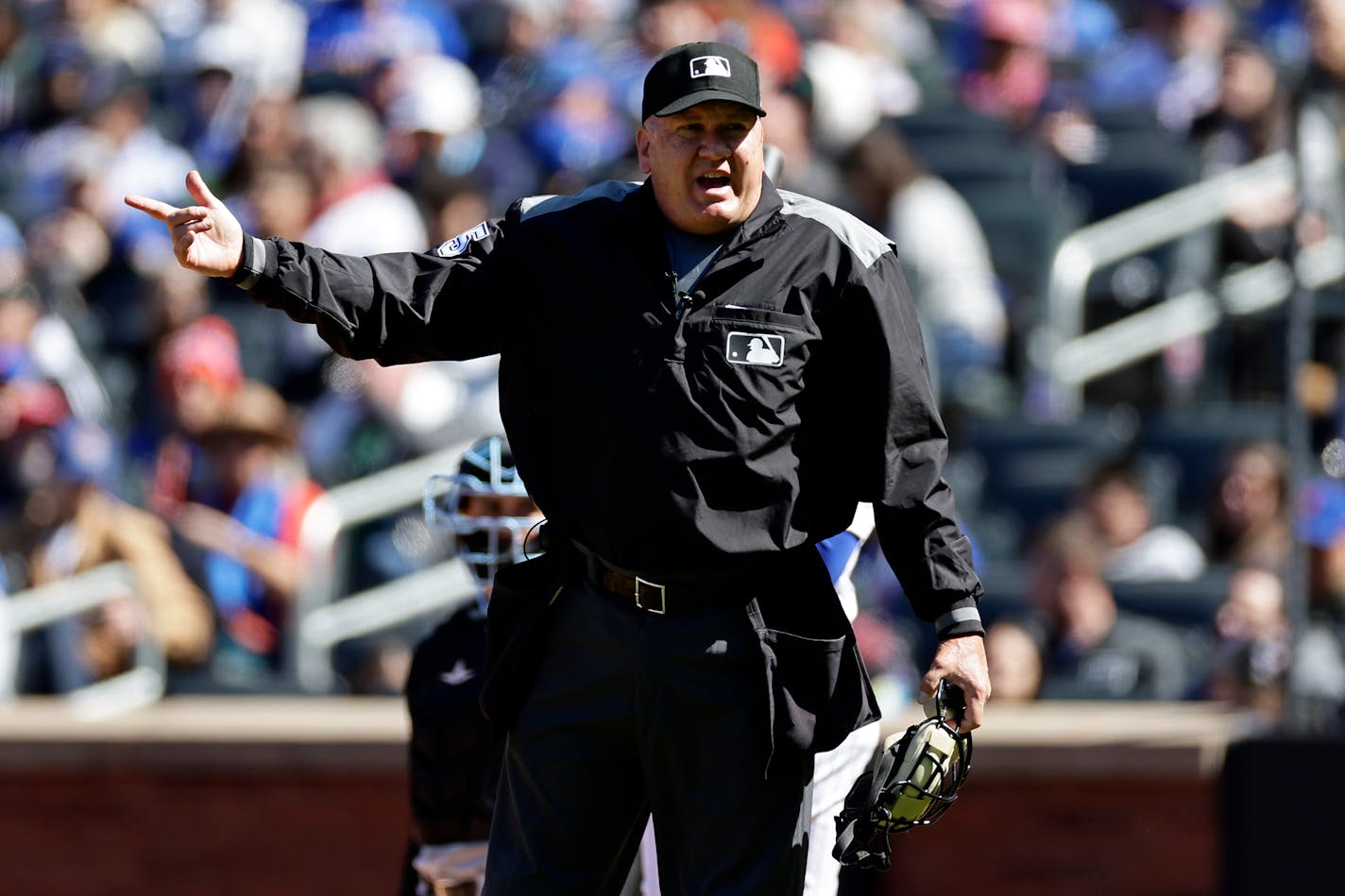 Home plate umpire Jeff Nelson (45) yells to the Miami Marlins dugout during the fourth inning of a baseball game against the New York Mets on Sunday, April 9, 2023, in New York. (AP Photo/Adam Hunger)