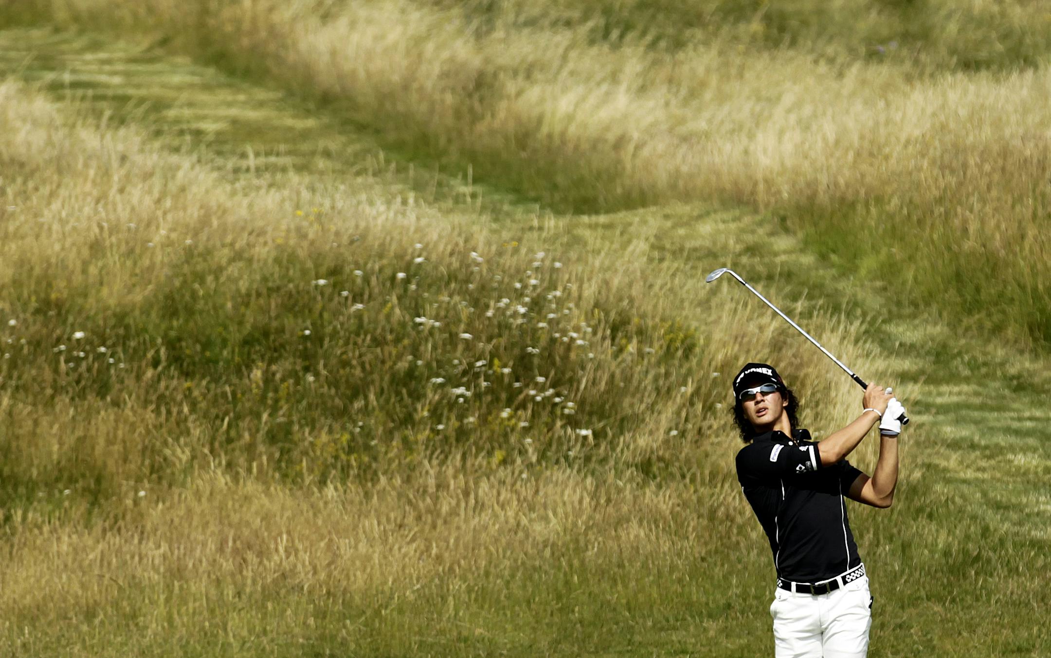 With the always intimidating rough in the background, Japan's Ryo Ishikawa played his shot on the No. 3 green during Monday's practice round at Royal St George's in southeastern England.