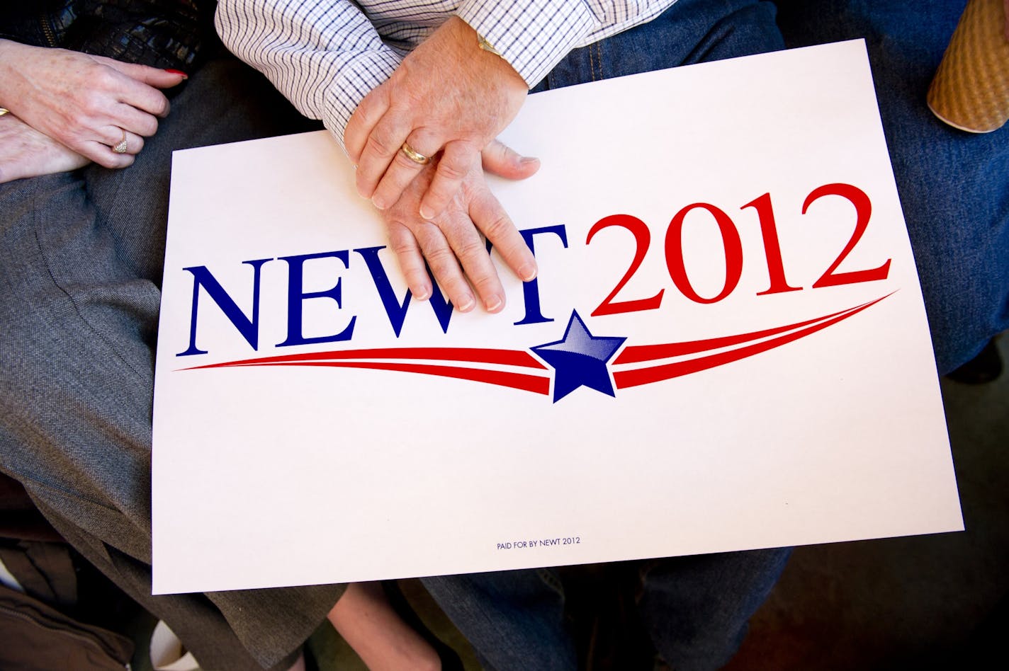 A supporter of former House Speaker Newt Gingrich, a candidate for the Republican presidential nomination, holds a sign during a campaign event at Elly's Tea & Coffee House in Muscatine, Iowa, Jan. 3, 2012. The curious political ritual that is the Iowa caucuses opens yet another race for the White House on Tuesday night.