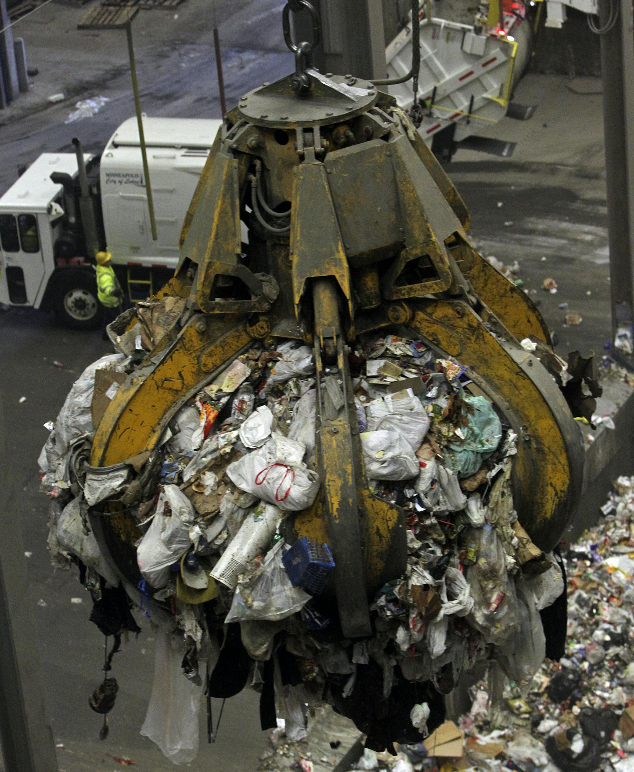 A crane grapple lifts a load of garbage for mixing before it is brought into the boiler for waste to energy conversion as a garbage truck dumps its load on the tipping floor Wednesday March 13, 2013, 2013, at the downtown HERC in Minneapolis, MN.] (DAVID JOLES/STARTRIBUNE) djoles@startribune.com A three-way power struggle is heating up over the burning capacity of Hennepin County's downtown facility. The Hennepin Energy Recovery Center (HERC) facility generates enough electricity to power about