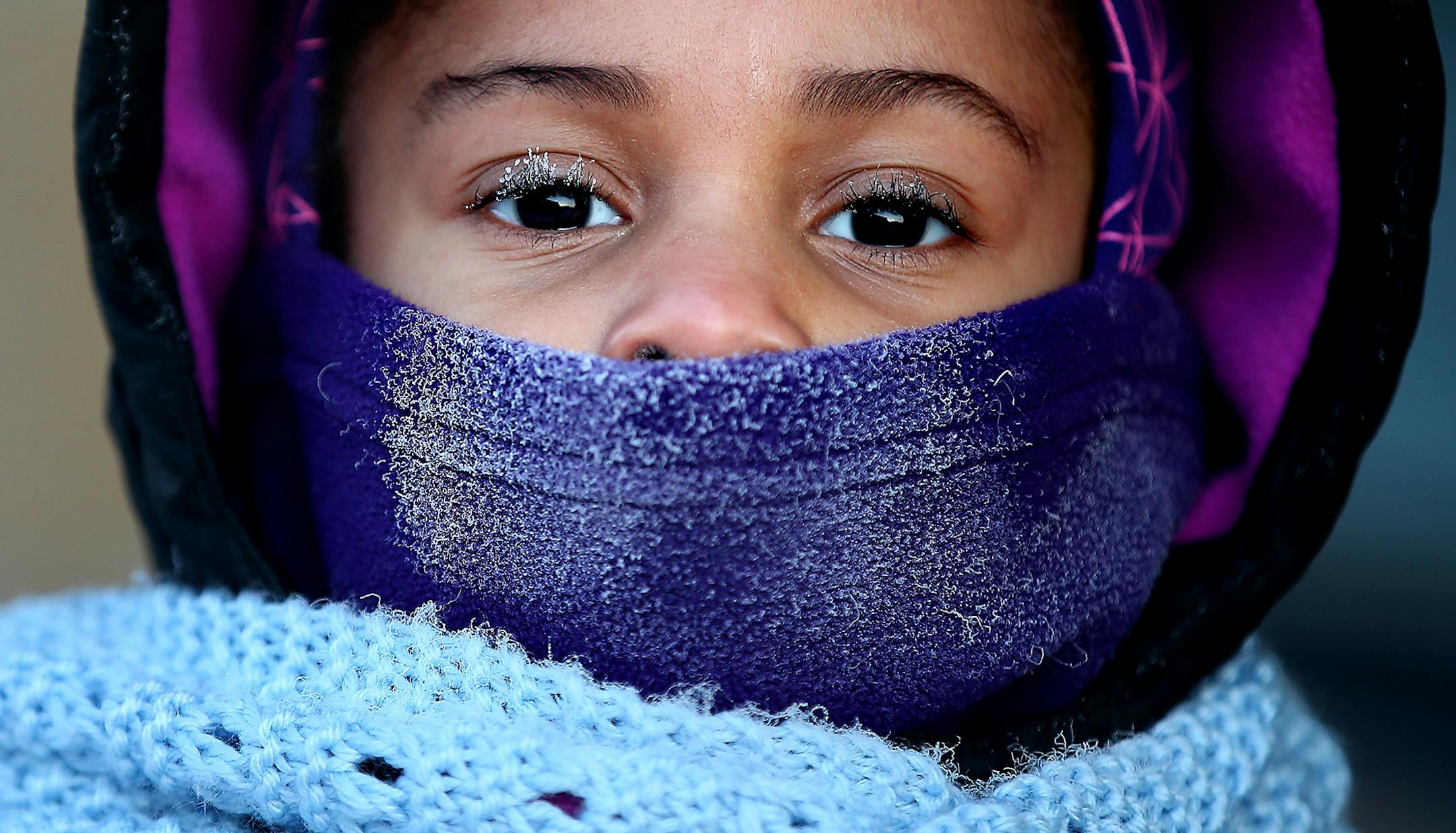 Despite the bitter cold and ice developing on her face, kindergartener Treashure Whitney-Taylor made her way back to Trinity First Elementary School with her father, Monday, January 5, 2015 in Minneapolis, MN.