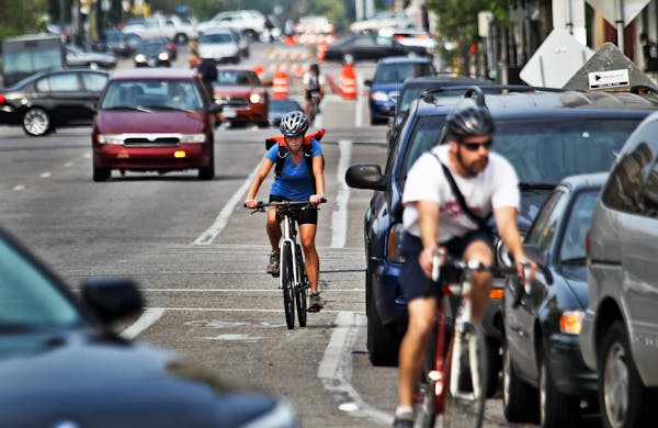 In this file photo, bicyclists and cars co-exist while heading south in heavy traffic along Portland Ave., near E. Grant Street on Aug. 30, 2012, in M