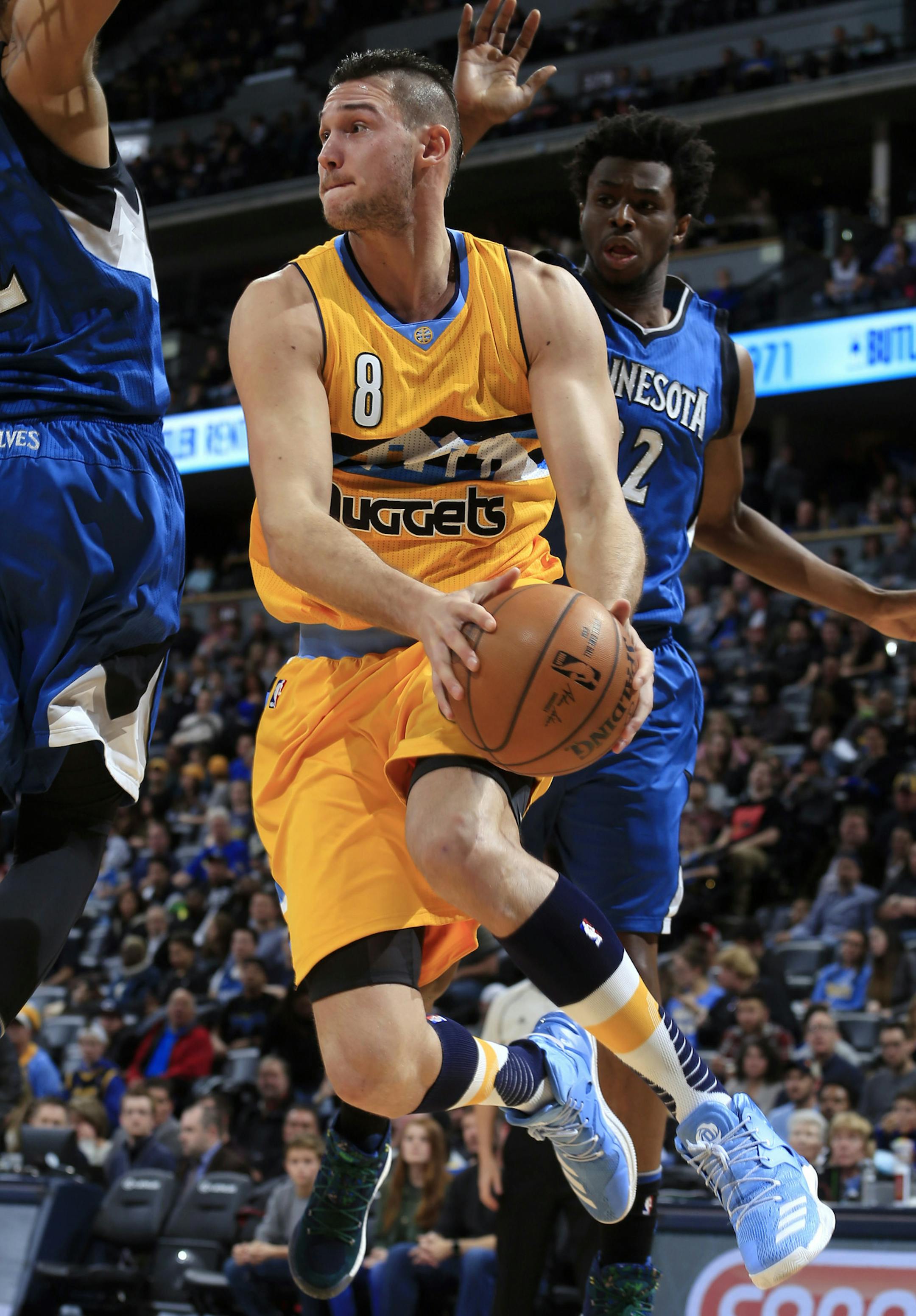 Denver Nuggets forward Danilo Gallinari (8) looks to pass in mid air around Minnesota Timberwolves center Karl-Anthony Towns (32) and Andrew Wiggins (22) during the second half of an NBA basketball game Wednesday, Dec. 28, 2016, in Denver. (AP Photo/Jack Dempsey)
