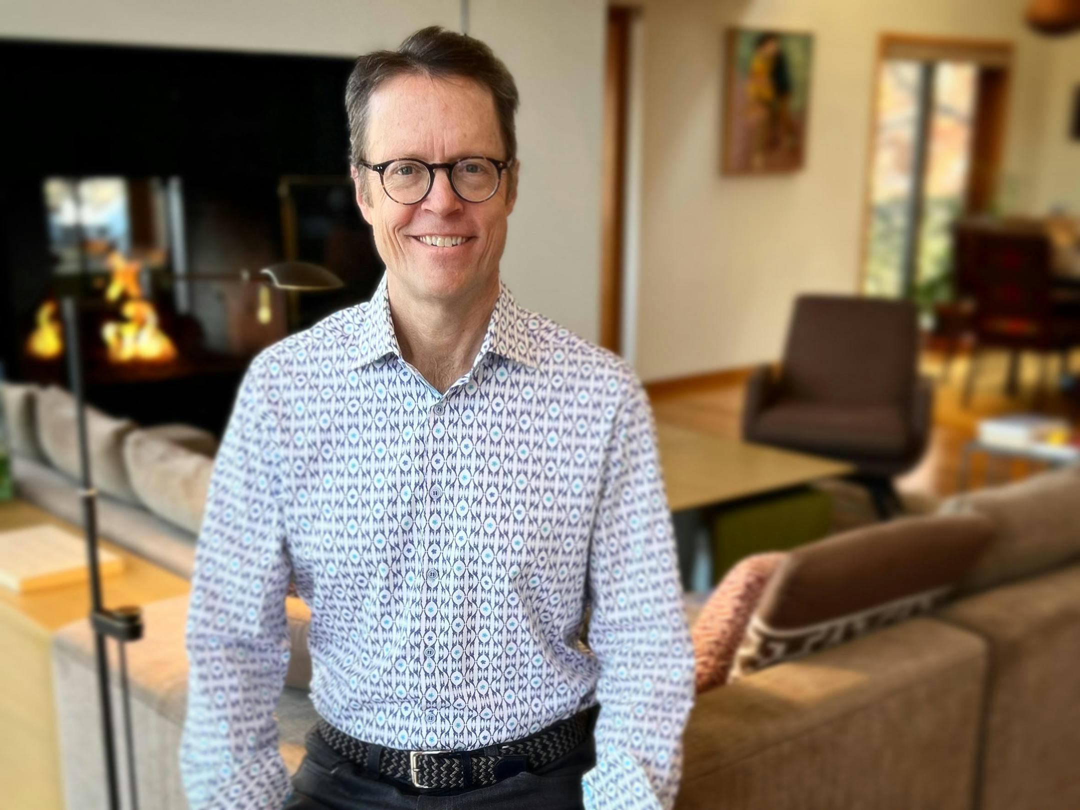author pictured, with fireplace and living room in the background