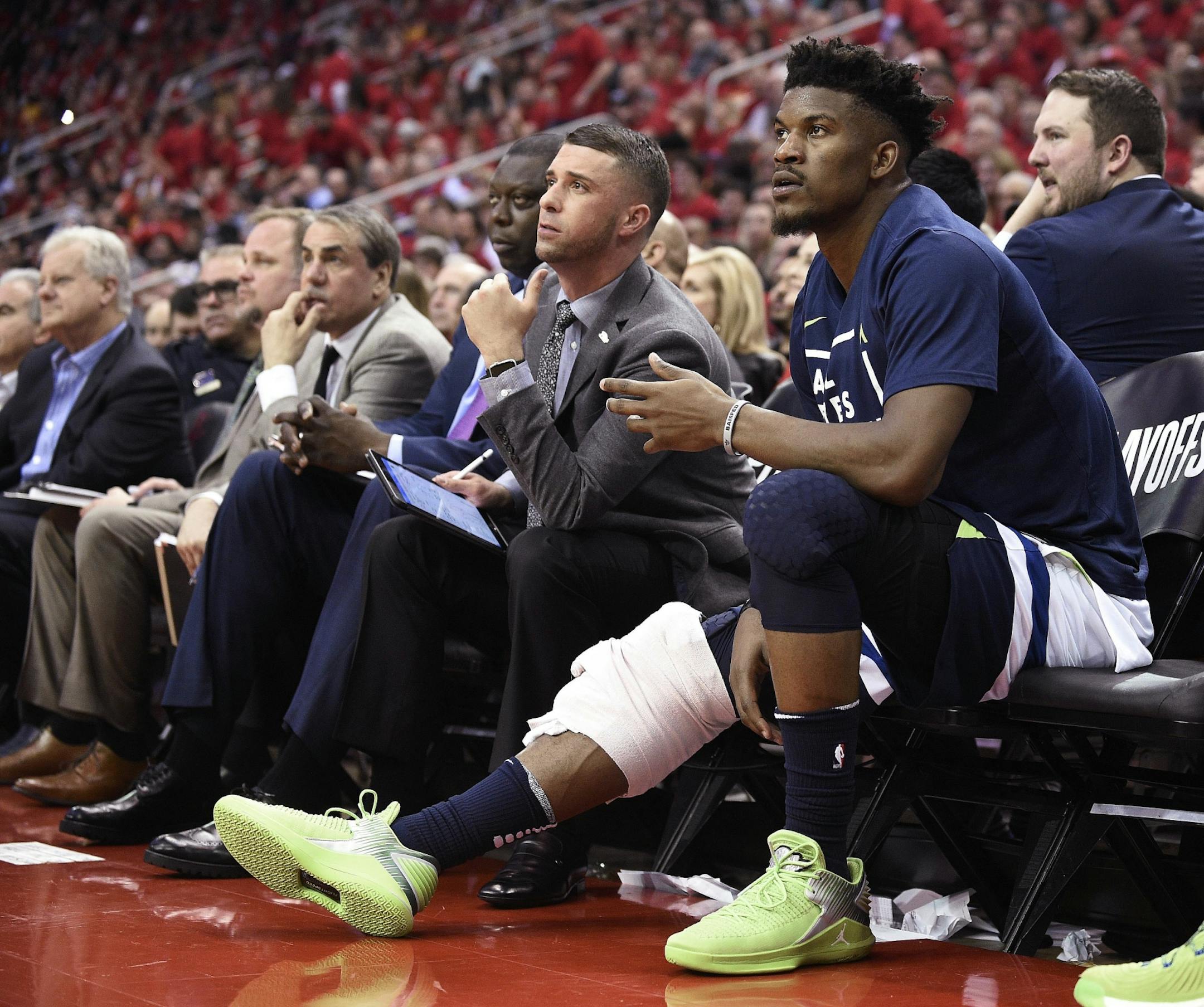 Minnesota Timberwolves guard Jimmy Butler, right, watches from the bench during the second half in Game 5 of the team's first-round NBA basketball playoff series against the Houston Rockets, Wednesday, April 25, 2018, in Houston.