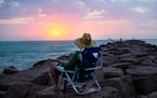 Henry Perez watches the sun rise from the jetties at Mansfield Cut during a beach camping trip in May 2018. (Pam LeBlanc/American-Statesman/TNS)