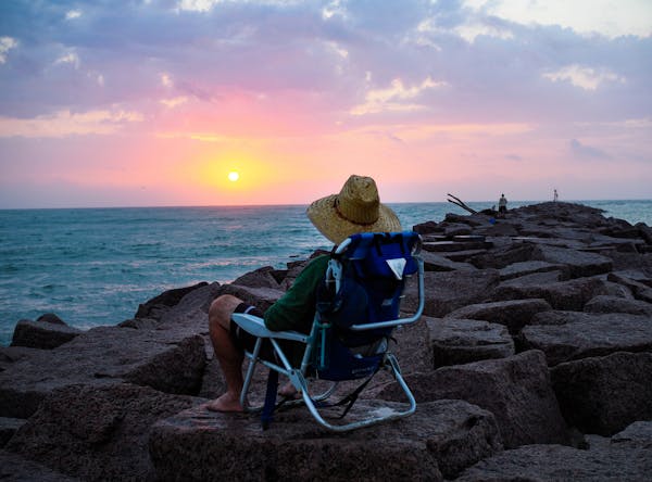 Henry Perez watches the sun rise from the jetties at Mansfield Cut during a beach camping trip in May 2018. (Pam LeBlanc/American-Statesman/TNS)
