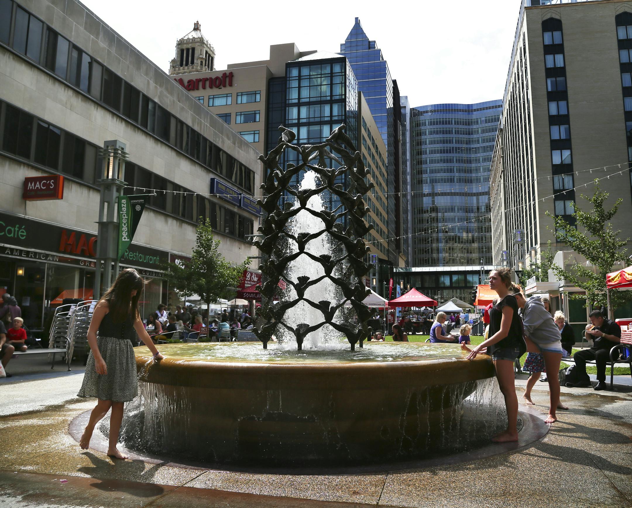 Thursdays on first & 3rd is a weekly outdoor market of over 100 art, craft and food vendors and live entertainment every Thursday throughout the summer in downtown Rochester, MN, near the Mayo Clinic and seen Thursday, August 8, 2013. Here, visiting her grandmother in Rochester, Sophia Villarrea, 12, of Kansas City, played in the fountain at the Peace Plaza, around the corner from First Ave. and Thursdays on first & 3rd.](DAVID JOLES/STARTRIBUNE) djoles@startribune.com Fueled by Mayo Clinic 