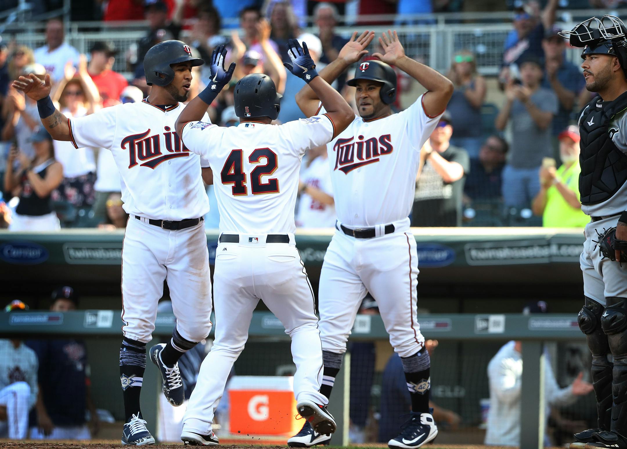 Eduardo Escobar (center) celebrated his eighth inning homer with Eddie Rosario, left, and Gregorio Petit