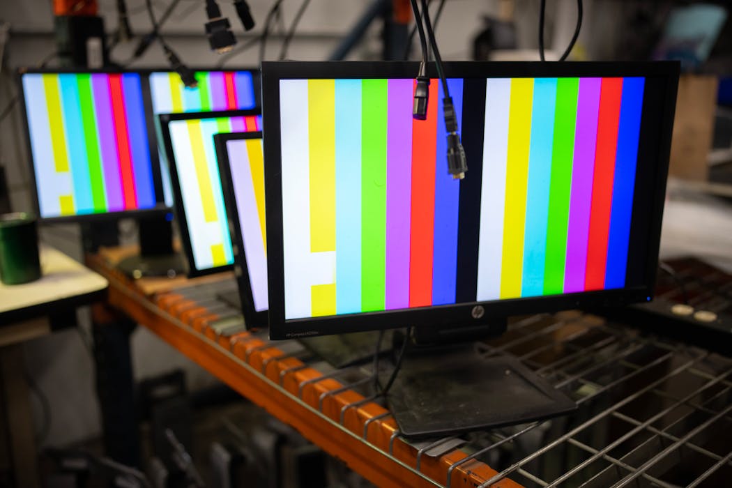 Computer monitors are tested in the display department at Repowered, one of the largest collectors of e-waste in Minnesota.