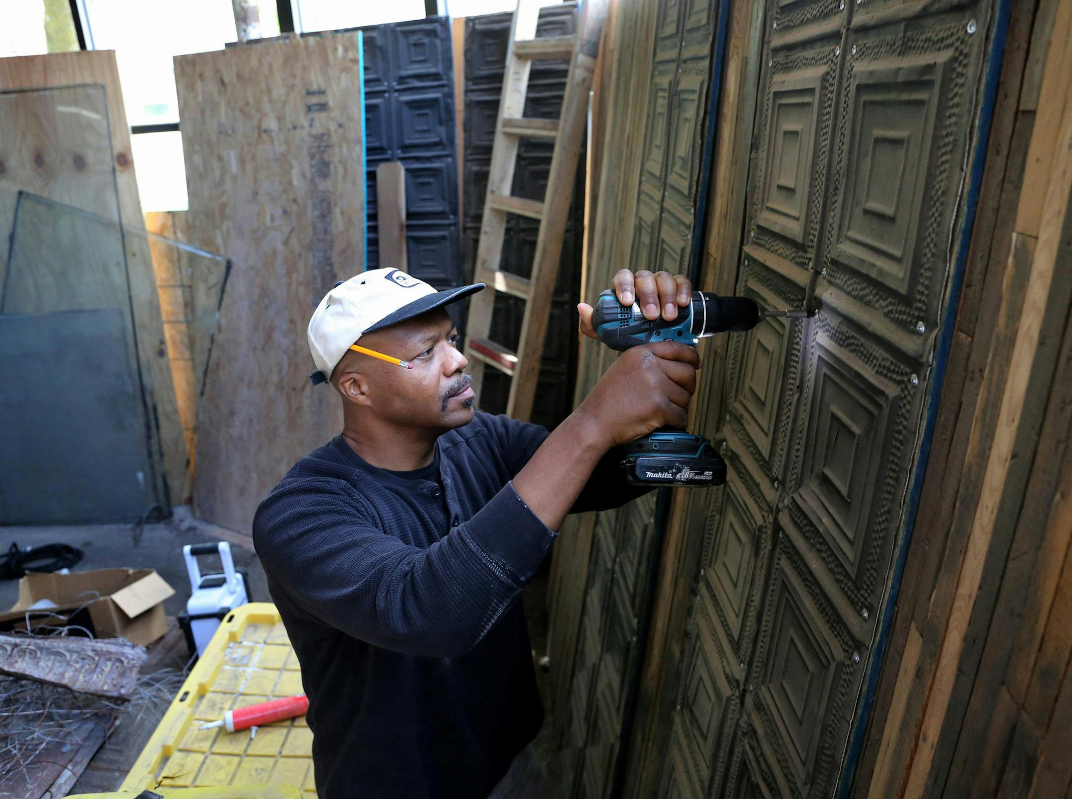 Tsadakeeyah Emmanuel works on May 31, 2016, on tin tiles to be used on the ceiling of his new vegan catering space in Chicago's South Shore neighborhood. Emmanuel says he once used an online lender for a loan, but was charged 75 percent interest. (Antonio Perez/Chicago Tribune/TNS) ORG XMIT: 1185696