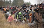 Migrants make their way to the checkpoint “Kuznitsa” at the Belarus-Poland border near Grodno, Belarus, on Monday, Nov. 15, 2021.