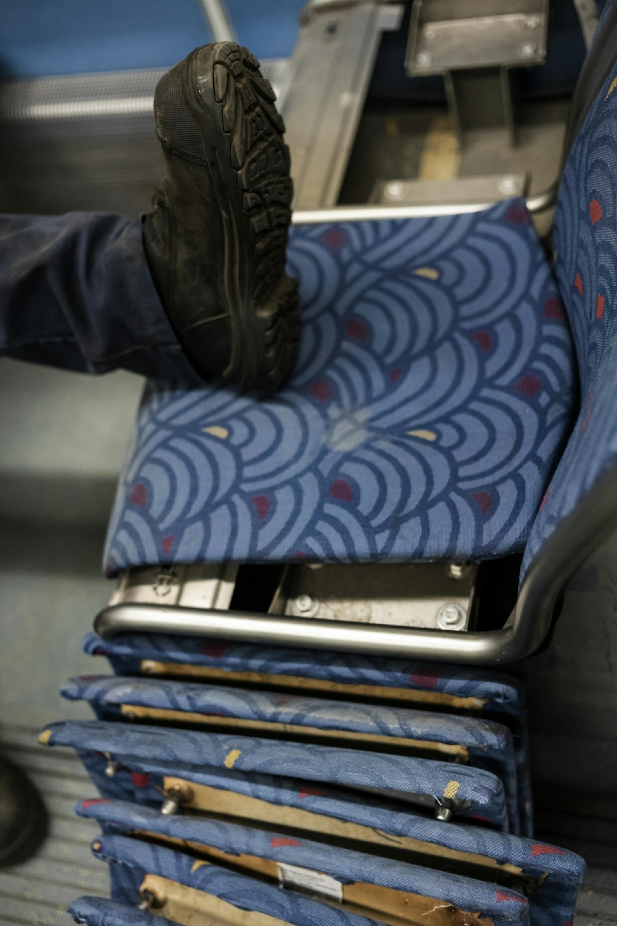 Electromechanical technician Timothy Malmstedt disassembled old cloth seats and installed new plastic seats as part of a test program to try seats that are easier to maintain.