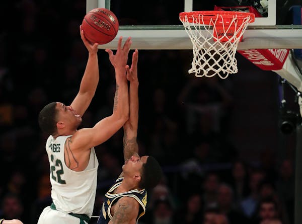 Michigan State guard Miles Bridges puts up a shot over Michigan guard Charles Matthews during the second half of a Big Ten Conference tournament semif