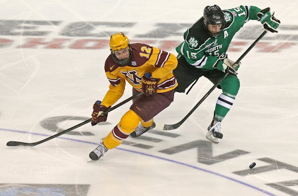 The Gophers' Justin Holl and North Dakota's Michael Parks battled on the ice during the second period of the Frozen Four at the Wells Fargo Center in 