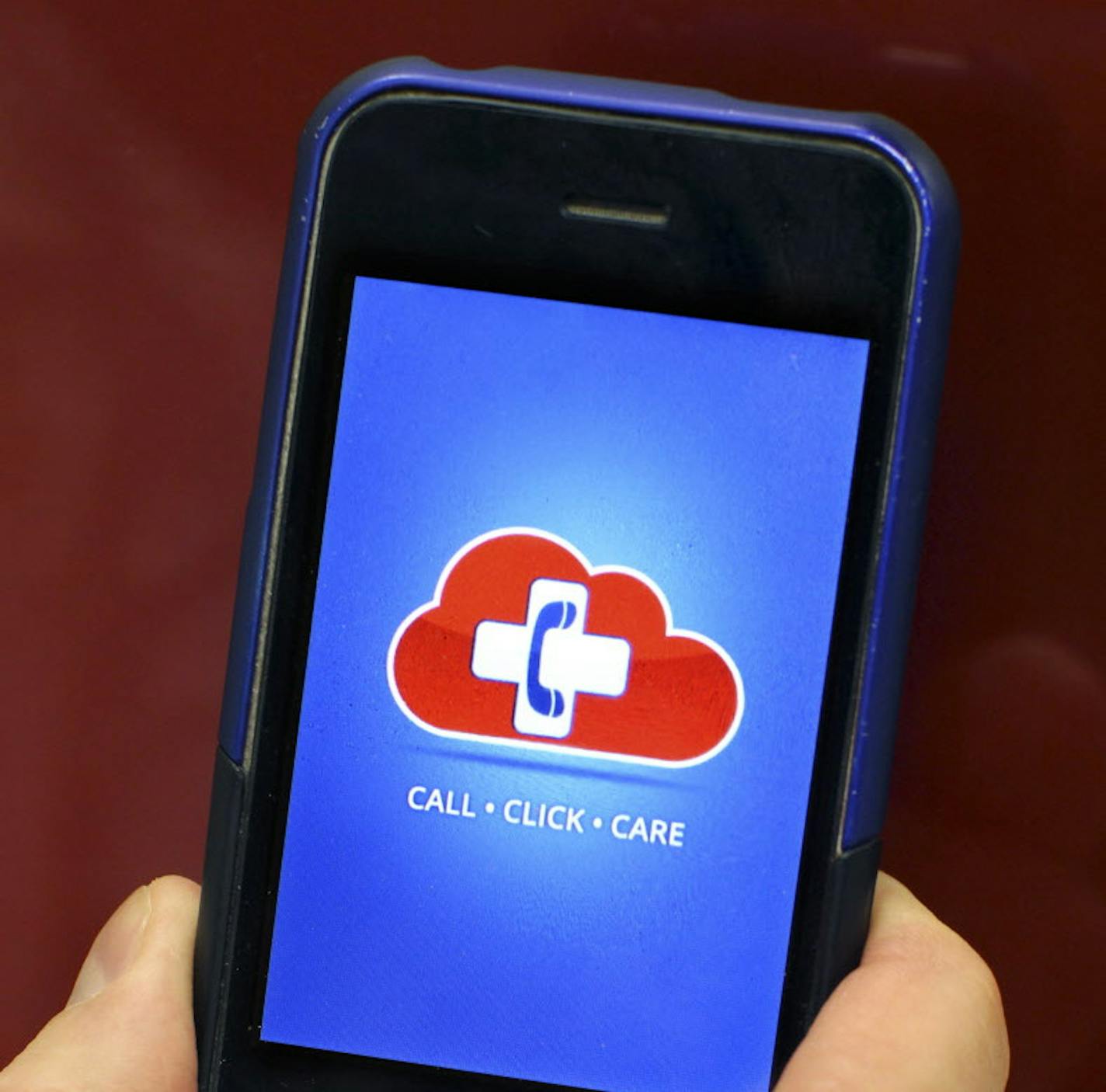 Dr. Douglas Smith, Chief Medical Officer for Consult A Doctor, holds his phone to display the soon-to-be-released app for Consult A Doctor at his office in Plymouth February 3, 2012. Subscribers have direct access 24/7 to physicians in their state of residence. (Courtney Perry/Special to the Star Tribune)