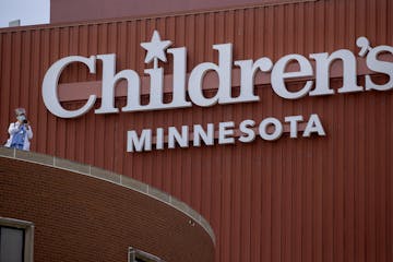 Medical staff gathered on a bridge near United Hospital and Children's Minnesota to watch the Minnesota National Guard statewide flyover in recognitio