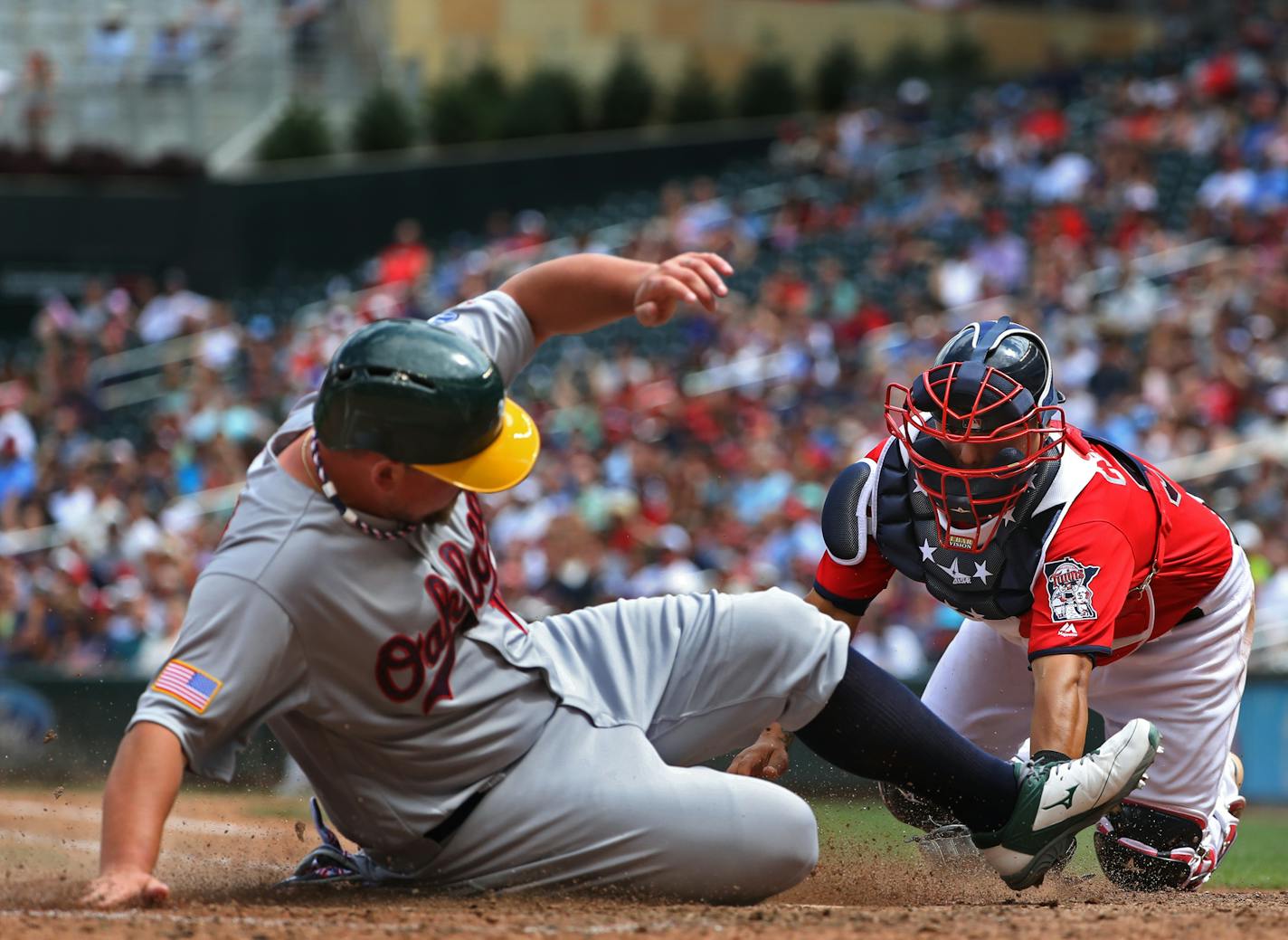 Billy Butler(16) scored at home before catcher Juan Centeno(37) could apply the tag in the seventh inning making the score 3-1.[At the Twins game against the A's at Target Field on 7/04/16. Richard Tsong-taatarii@startribune.com