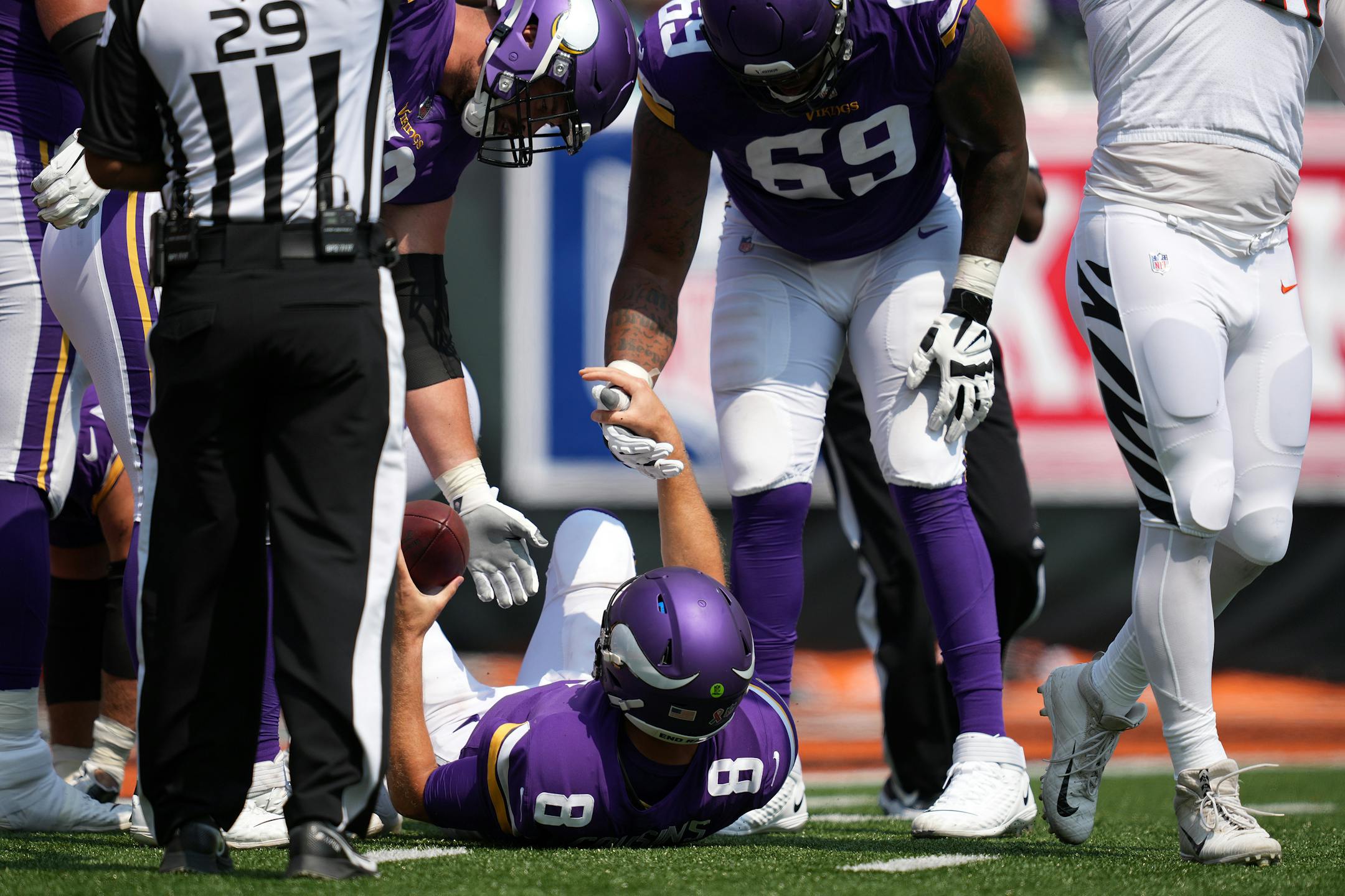 Minnesota Vikings quarterback Kirk Cousins (8) was helped up off the field after he got sacked by Cincinnati Bengals defensive tackle Larry Ogunjobi (65) in the first quarter.