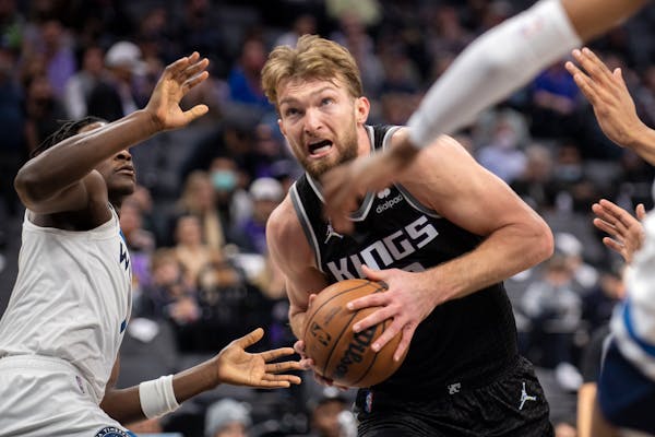 Kings center Domantas Sabonis (10) drives past Timberwolves forward Anthony Edwards, left, during the second half Wednesday. 
