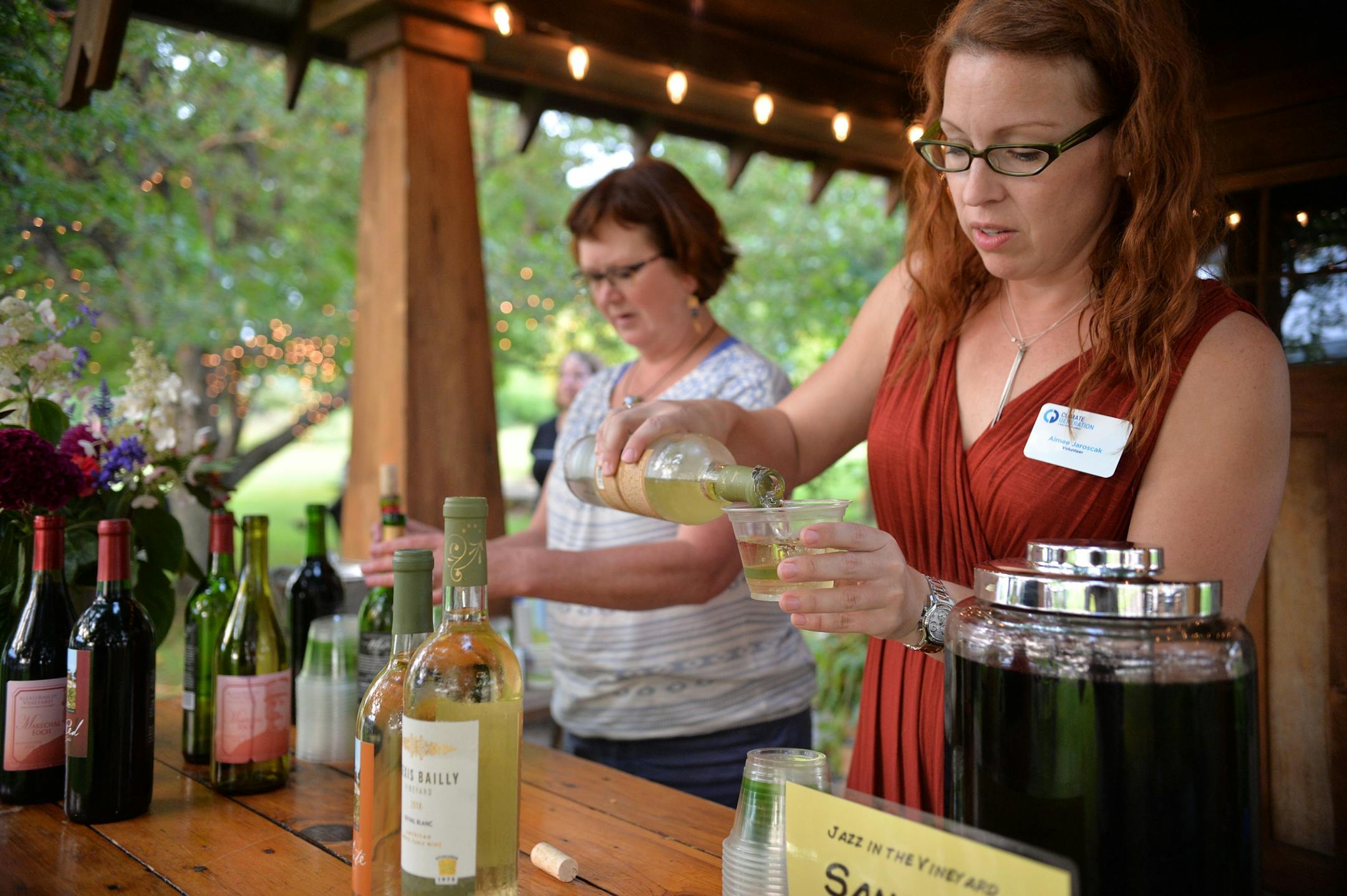 Climate Generation volunteer, Aimee Jaroscak pours a glass of white wine during Wine & Dine for Climate at Alexis Bailly Vineyard in Hastings.