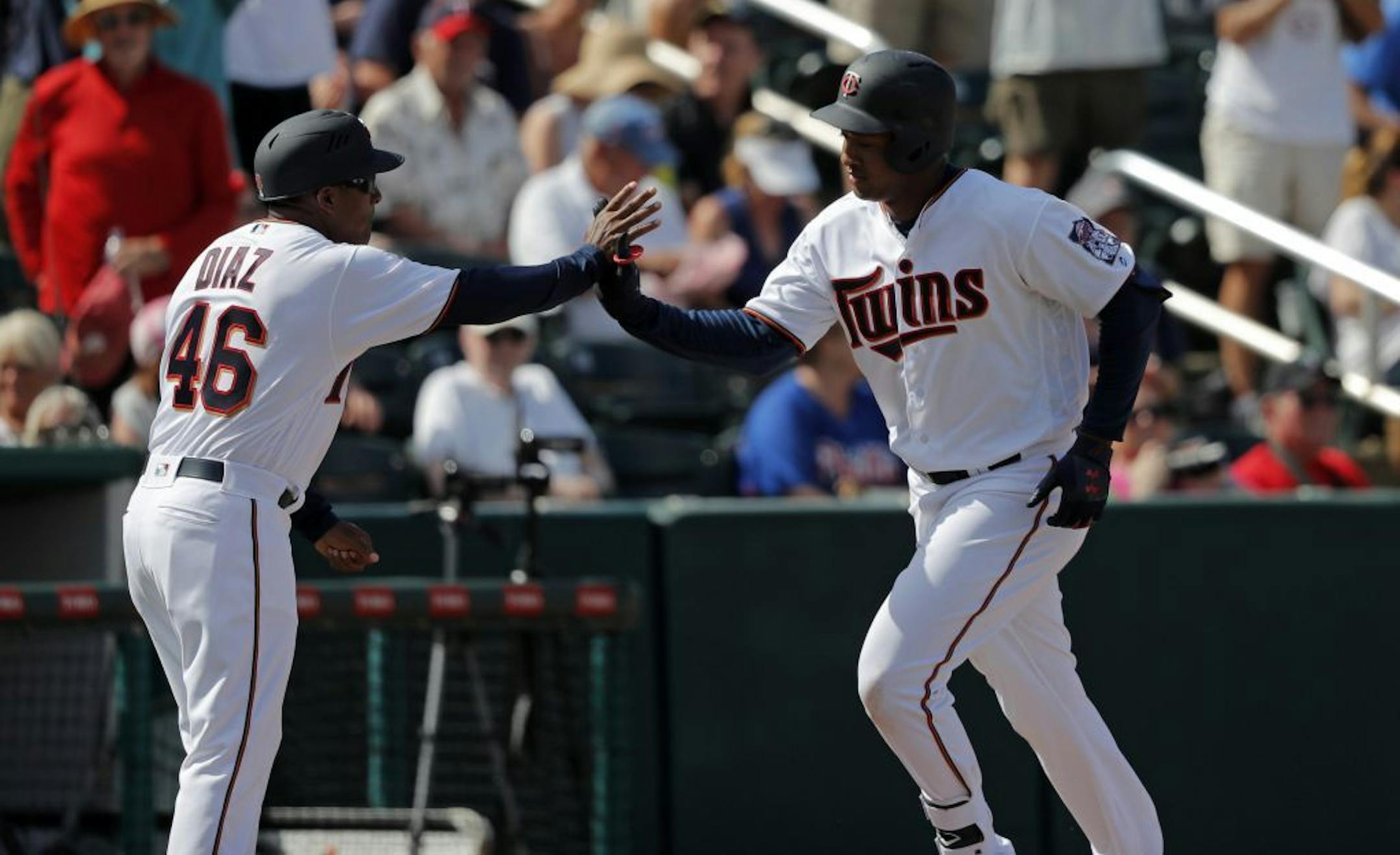 The Twins' Jonathan Schoop was greeted by third base coach Tony Diaz while rounding third base on his two-run home run in the fifth inning of a spring training game against the Phillies in Fort Myers, Fla., on Sunday.