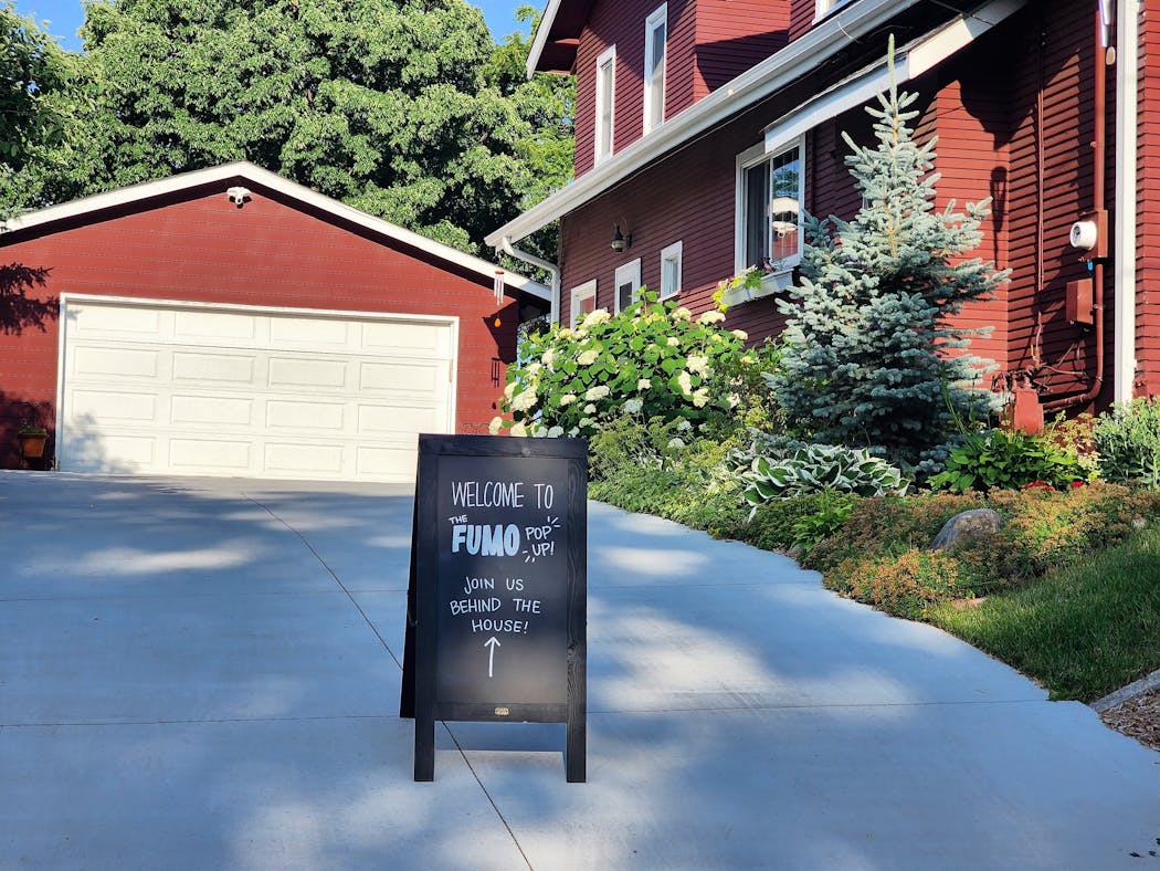 A sign points to the Fumo Collective burger pop-up at a backyard birthday party in Edina.