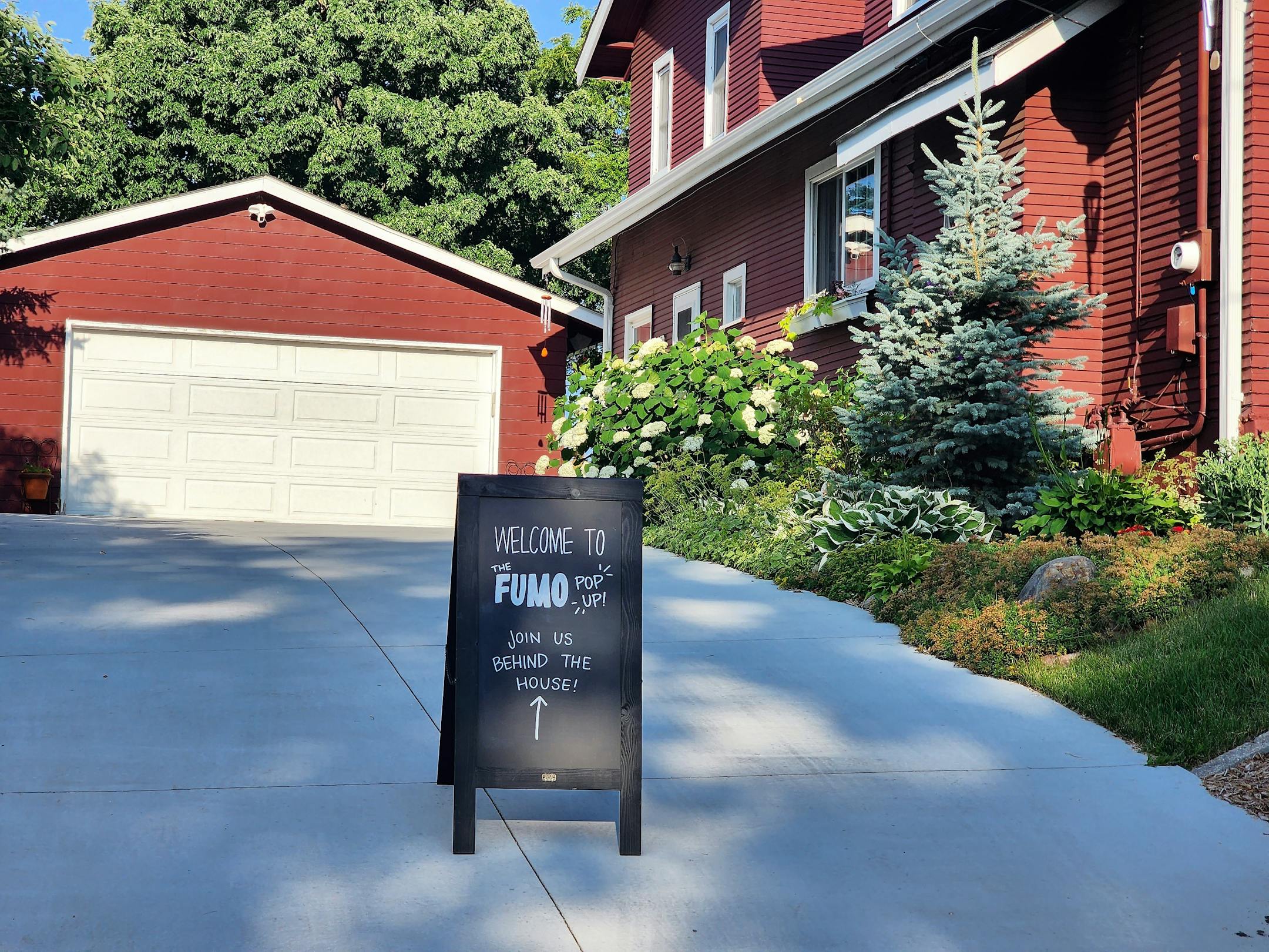 A sign points to the Fumo Collective burger pop-up at a backyard birthday party in Edina.
