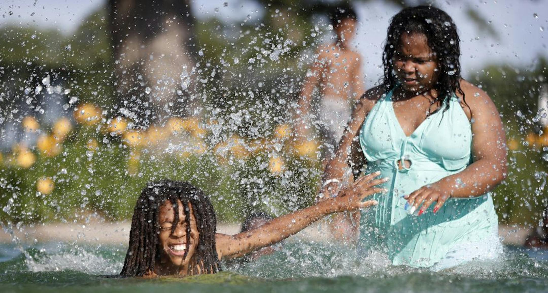 Maria Ellis 20, right splashed water on DaKayo Lattimore 9, at Webber Park pool after it reopened Tuesday July 10, 2018 in Minneapolis , MN.