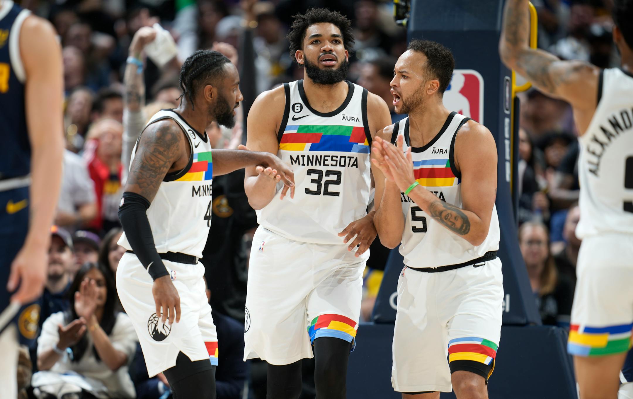 Minnesota Timberwolves guard Jaylen Nowell, left, congratulates center Karl-Anthony Towns (32) on a basket against the Denver Nuggets, next to forward Kyle Anderson during the second half of Game 2.
