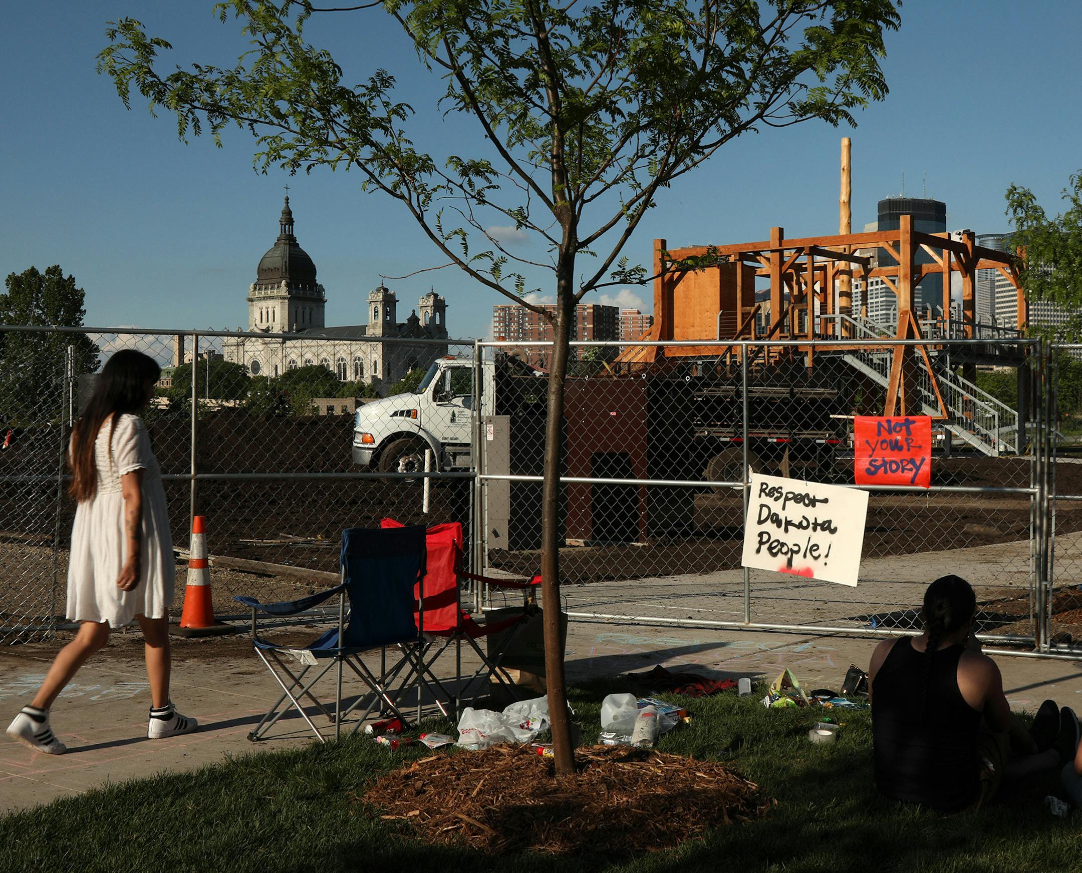 Dakota community members, from left, Graci Horne, Thomas Kenote Jr. and Sasha Huston Brown sat outside the Minneapolis Sculpture Garden protesting "Scaffold" by Sam Durant which depicts the 1867 hangings of 38 Dakota men. ] ANTHONY SOUFFLE &#xef; anthony.souffle@startribune.com Protesters sat outside the Minneapolis Sculpture Garden in response to "Scaffold" by Sam Durant which depicts the 1867 hangings of 38 Dakota men Friday, May 26, 2017 in Minneapolis. ORG XMIT: MIN1705261925351861
