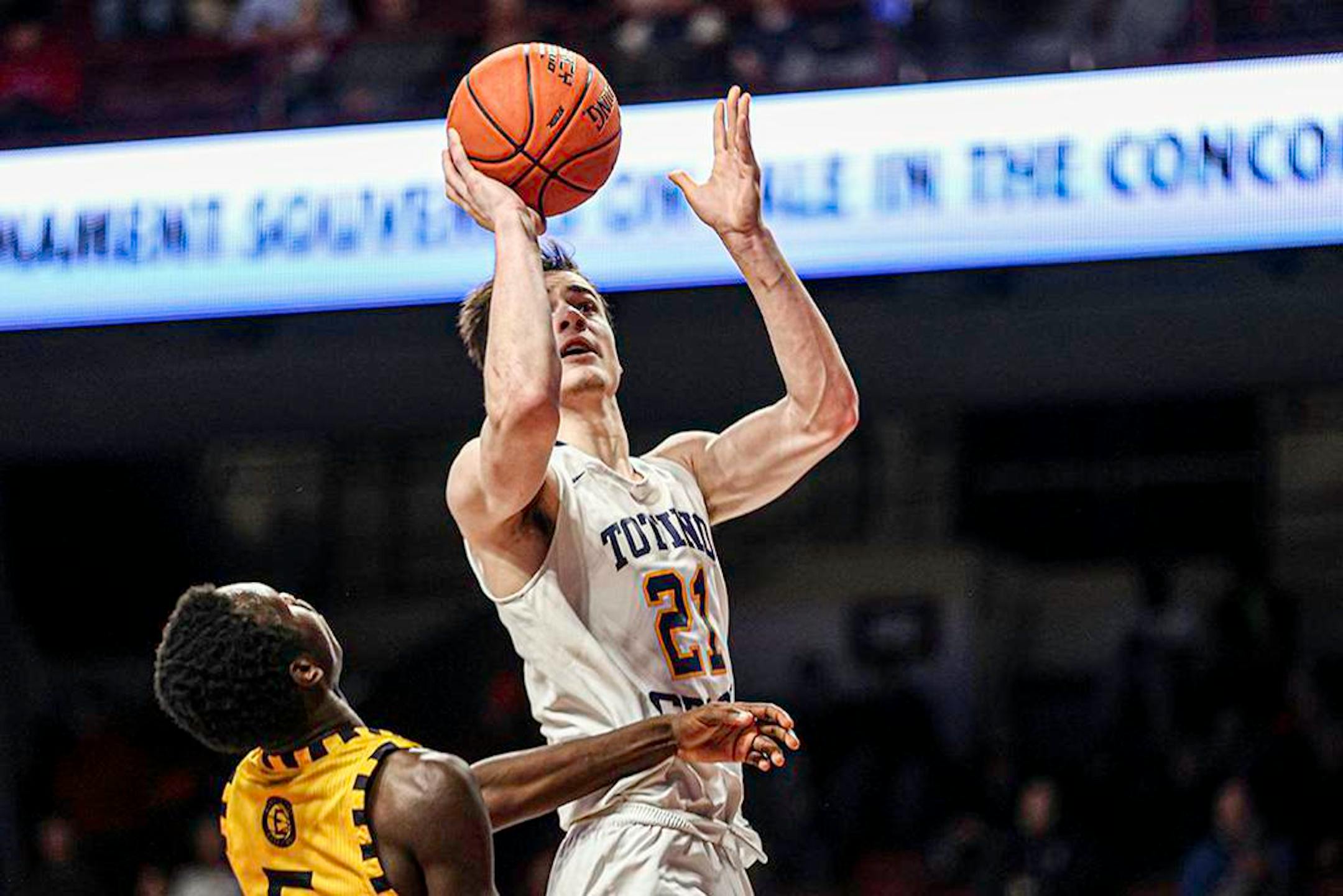 Patrick Bath (21) goes over Puohlrah Gong (5) or two of his 27 points in Totino-Grace's 77-39 victory over Mankato East. Class 3A semifinals, Totino-Grace vs. Mankato East, at Williams Arena, 3-23-22. Photo by Mark Hvidsten, SportsEngine