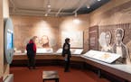 Visitors walk around the "Many Voices, Many Stories, One Place" exhibit. The exhibit includes stories from Dakota and Ojibwe people, Japanese-American