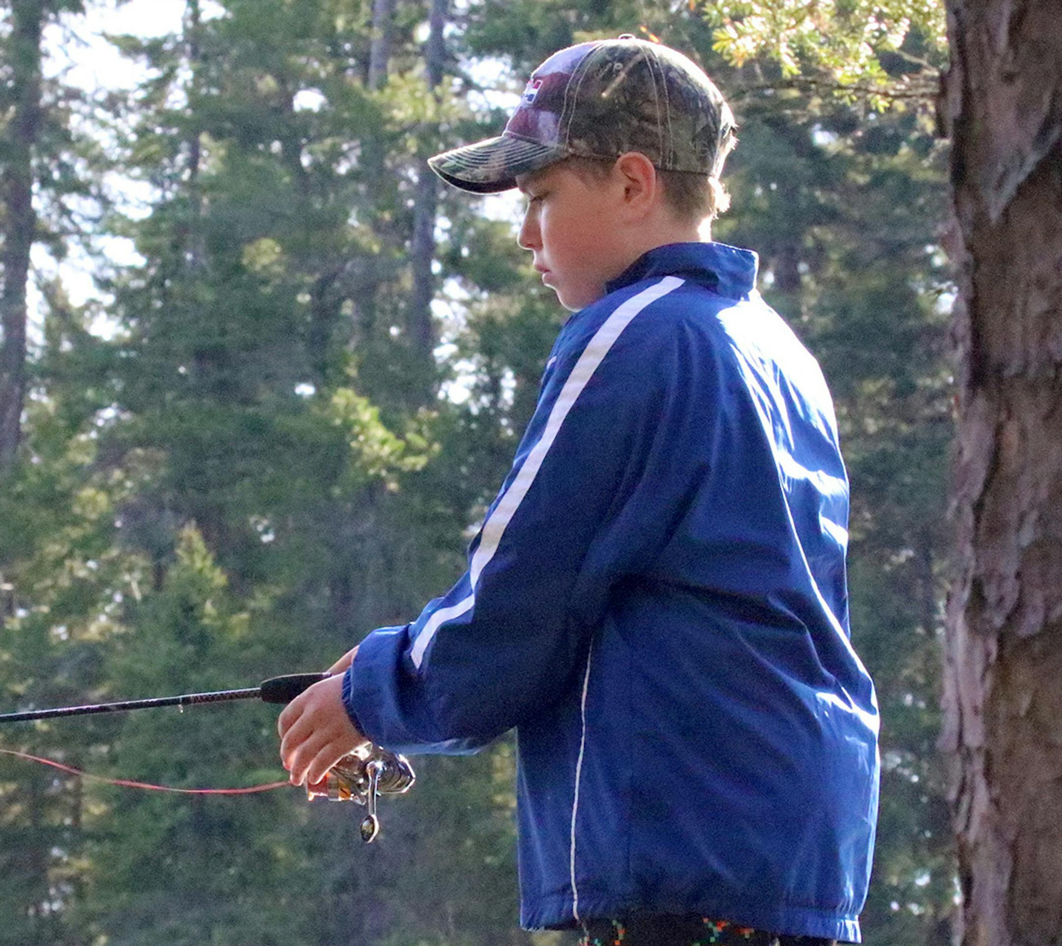 Standing on a ridge above Sawbill Lake, Joe Kennedy, 12, fishes from his campsite when the wind was too strong to enjoy the canoe. On his first-ever trip to the Boundary Waters Canoe Area, he took in the wilderness as a playground.