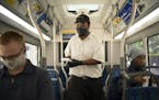 Aweld Hussein offered free masks to riders of a Metro Transit bus stopped on the corner of 7th Street and Nicollet Avenue on Thursday, June 25. Face c