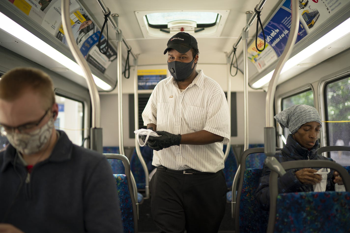 Aweld Hussein offered free masks to riders of a Metro Transit bus stopped on the corner of 7th Street and Nicollet Avenue on Thursday, June 25. Face coverings have been required since May 18 on board all Metro Transit buses and trains.