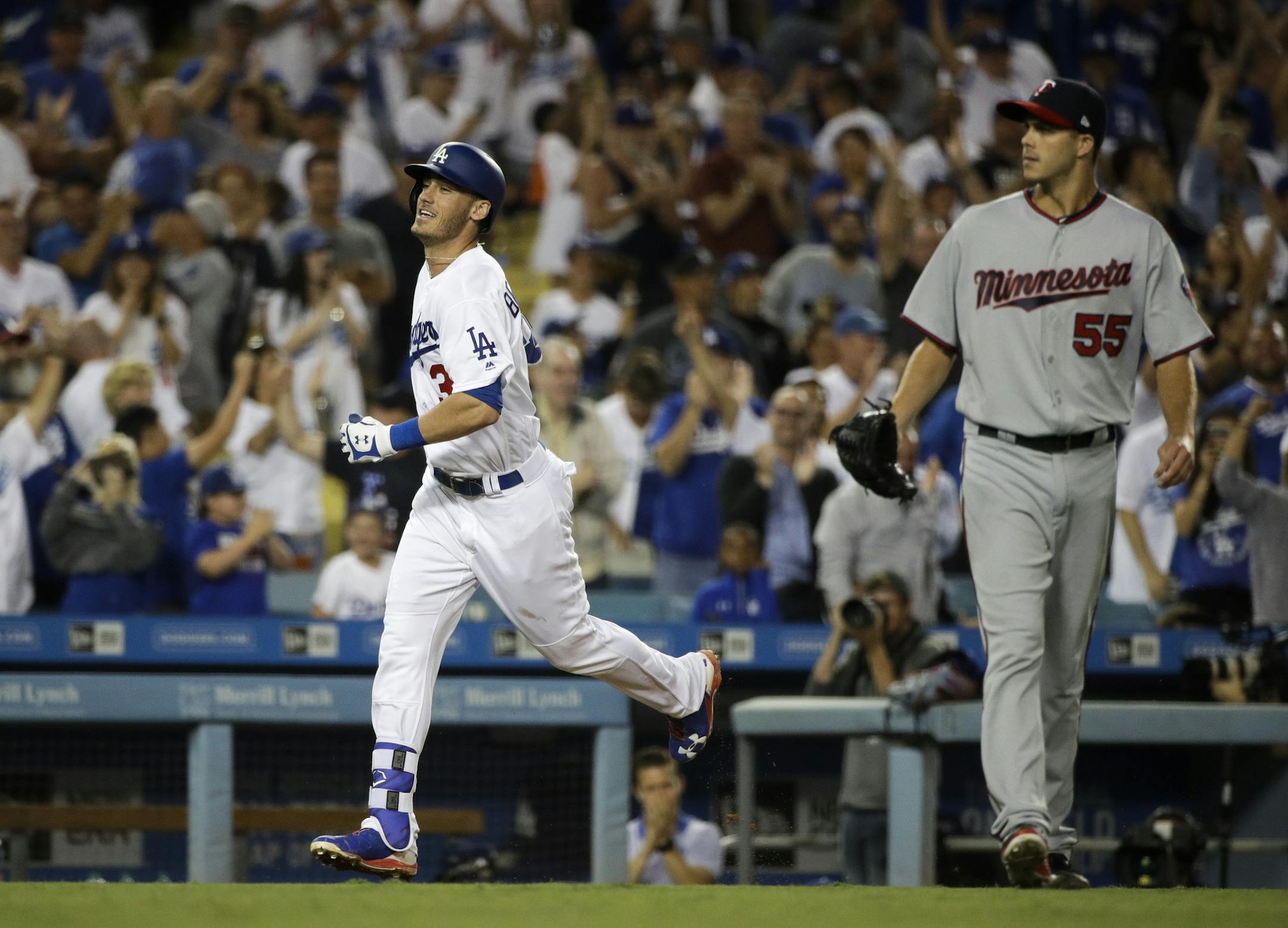 Los Angeles Dodgers' Cody Bellinger, left, runs toward home plate past Minnesota Twins relief pitcher Taylor Rogers after hitting a three-run home run during the eighth inning of a baseball game, Monday, July 24, 2017, in Los Angeles. (AP Photo/Jae C. Hong) ORG XMIT: LAD128