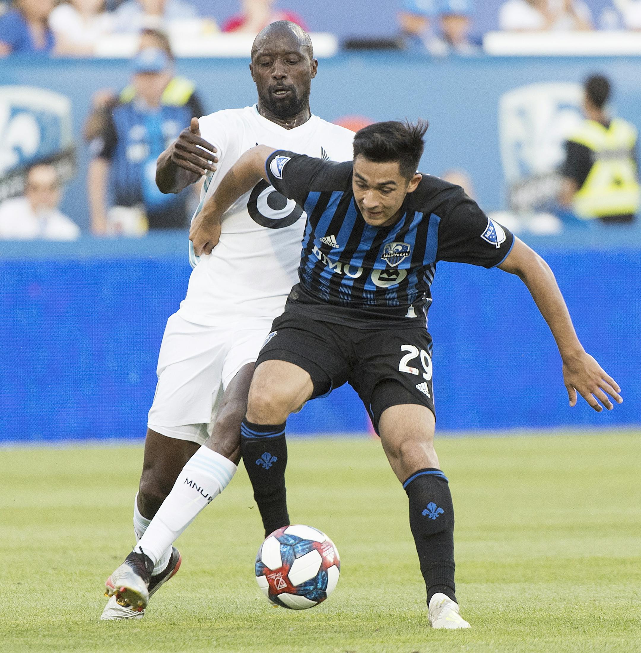 Montreal Impact's Mathieu Choiniere, right, challenges Minnesota United's Lawrence Olum during first half of an MLS soccer match in Montreal, Saturday, July 6, 2019. (Graham Hughes/The Canadian Press via AP)